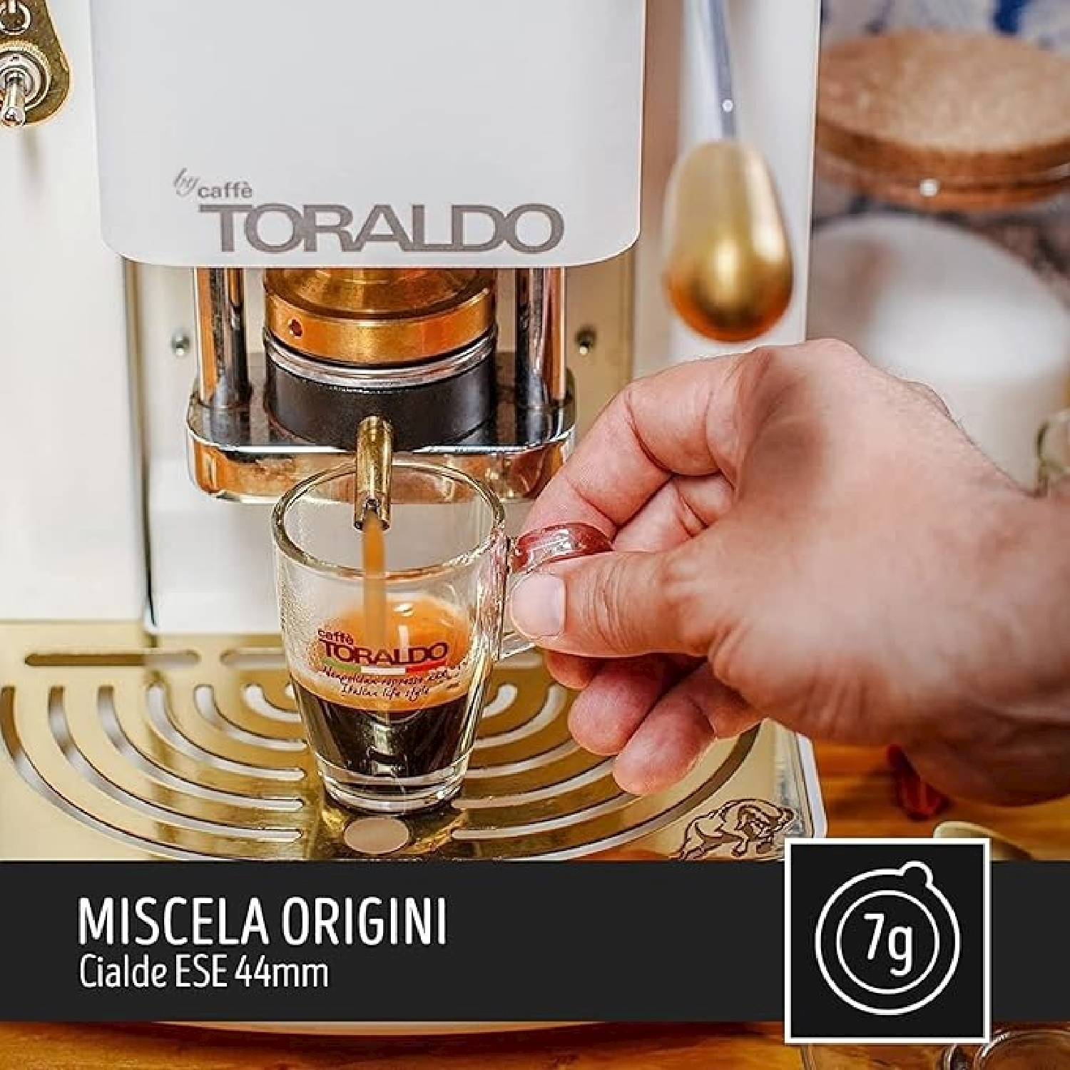 Una persona versa il caffè in una tazza di vetro da una macchina.