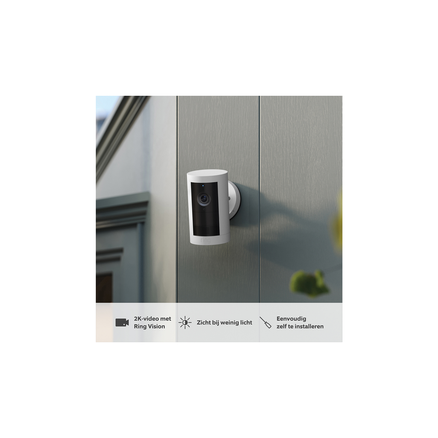 Een witte Ring-beveiligingscamera gemonteerd op een grijze muur, met tekst over 2k-zicht.