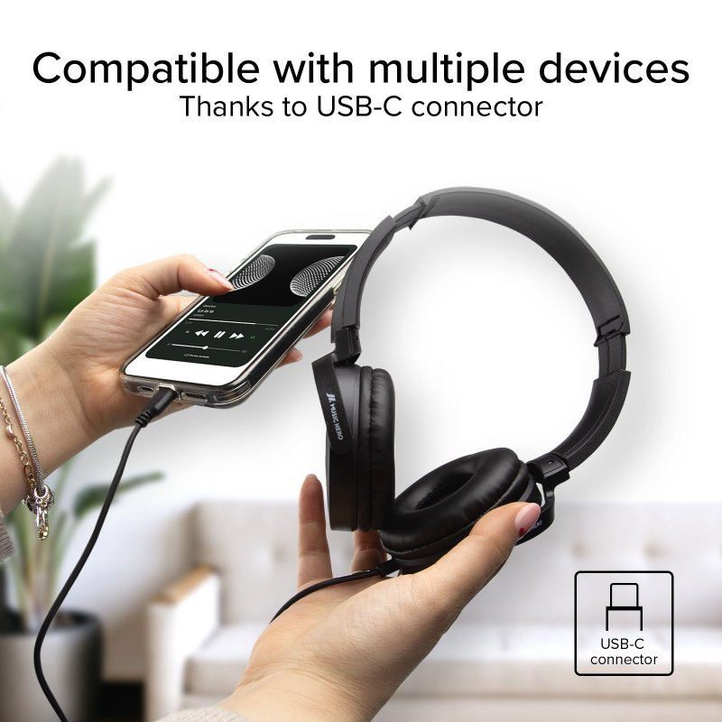 Eine Frau hält ein Telefon, das mit schwarzen Kopfhörern mit einem USB-C-Anschluss verbunden ist. Weißer Hintergrund.