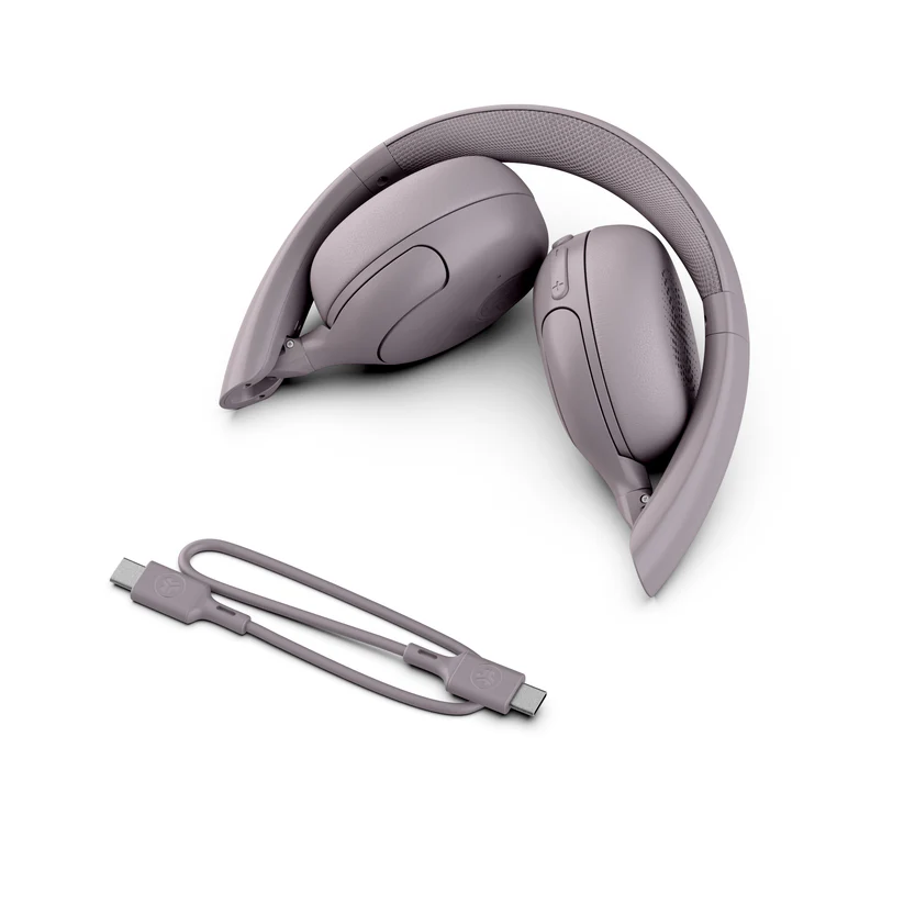 Gefaltete graue Kopfhörer und ein Ladekabel auf weißem Hintergrund. Das Kabel ist angeschlossen.