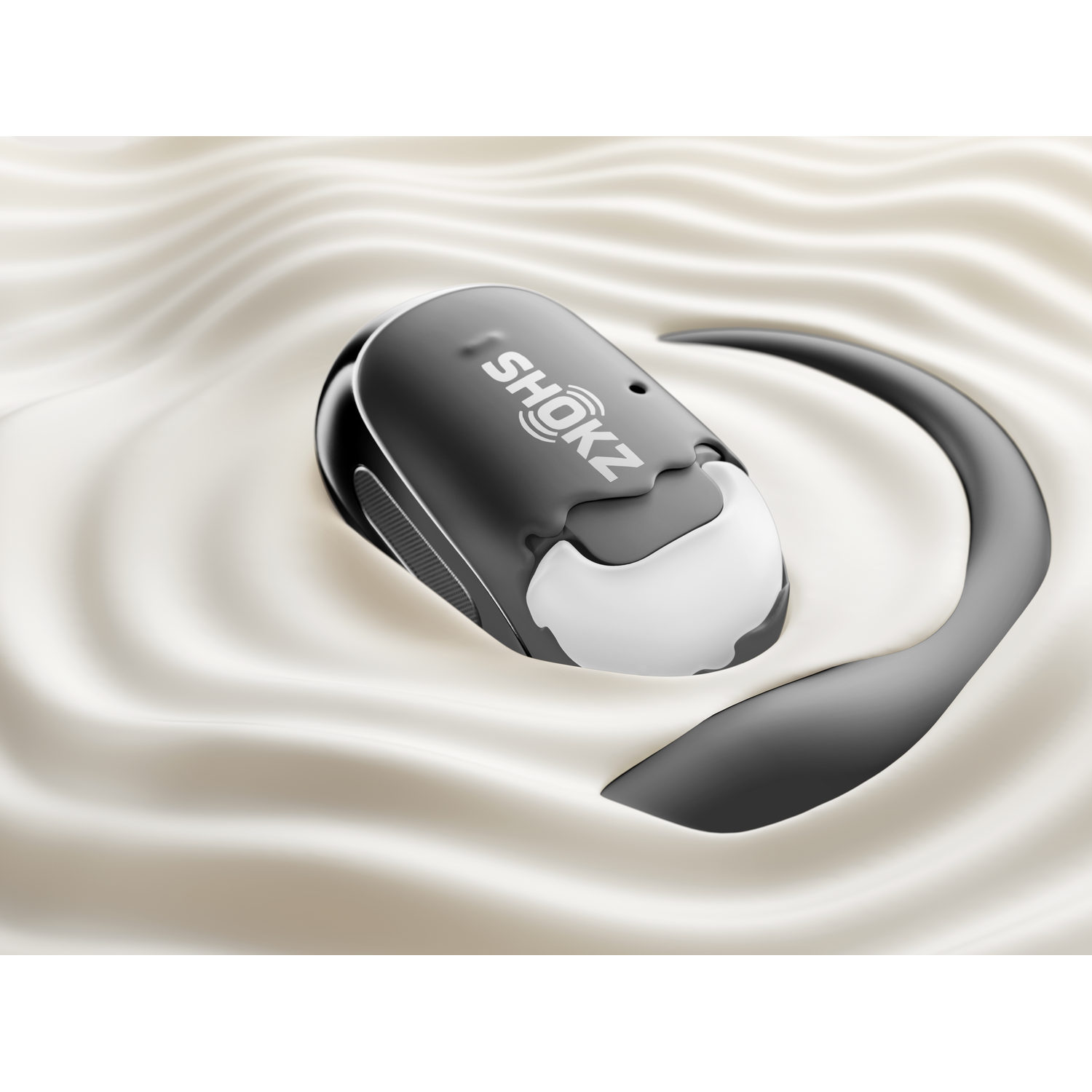 Shokz headphone in liquid, with a wavy surface.