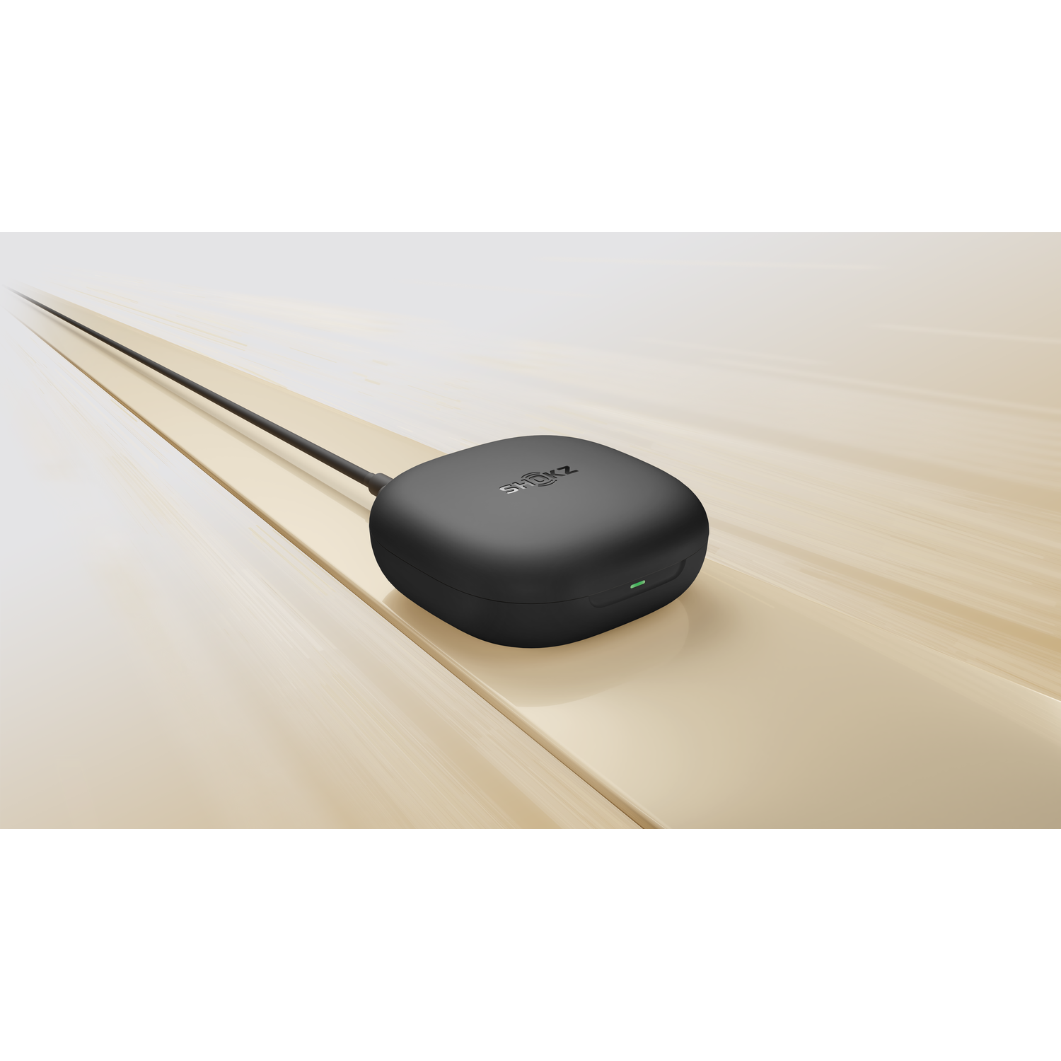 Black Shokz charging case with a cable, on a wooden surface.