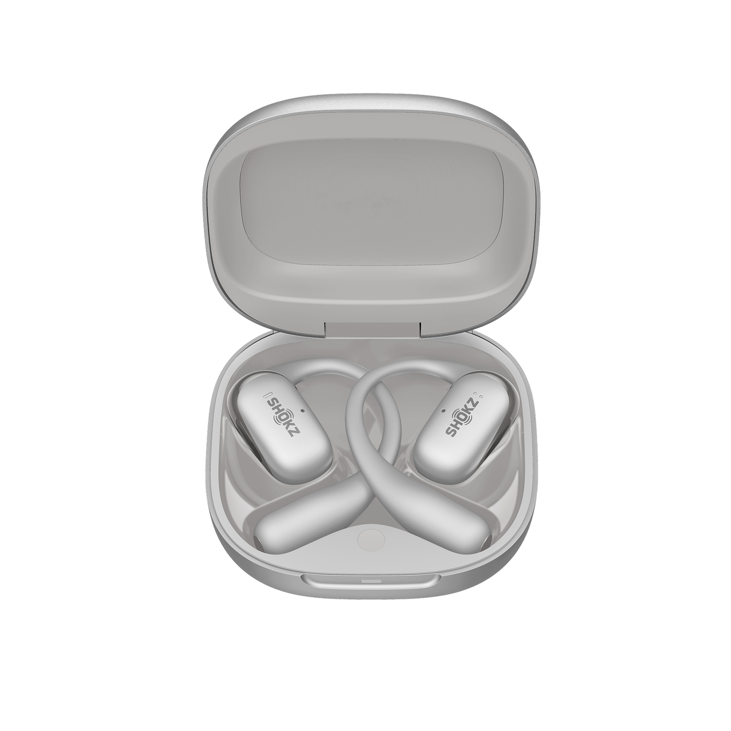White Shokz headphones inside open charging case, on white.