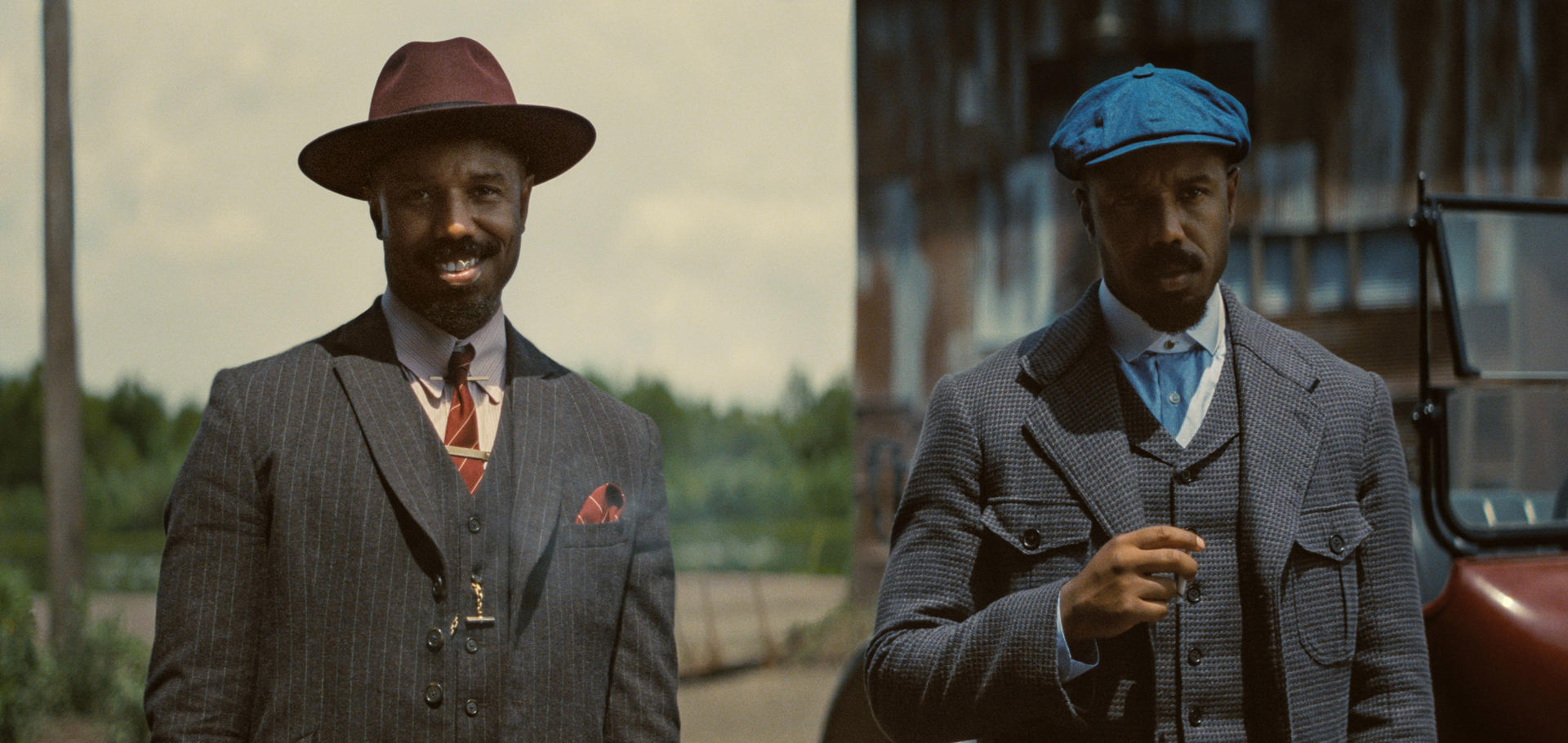 Zwei Männer in Vintage-Outfits, einer mit Hut, der andere mit Mütze.