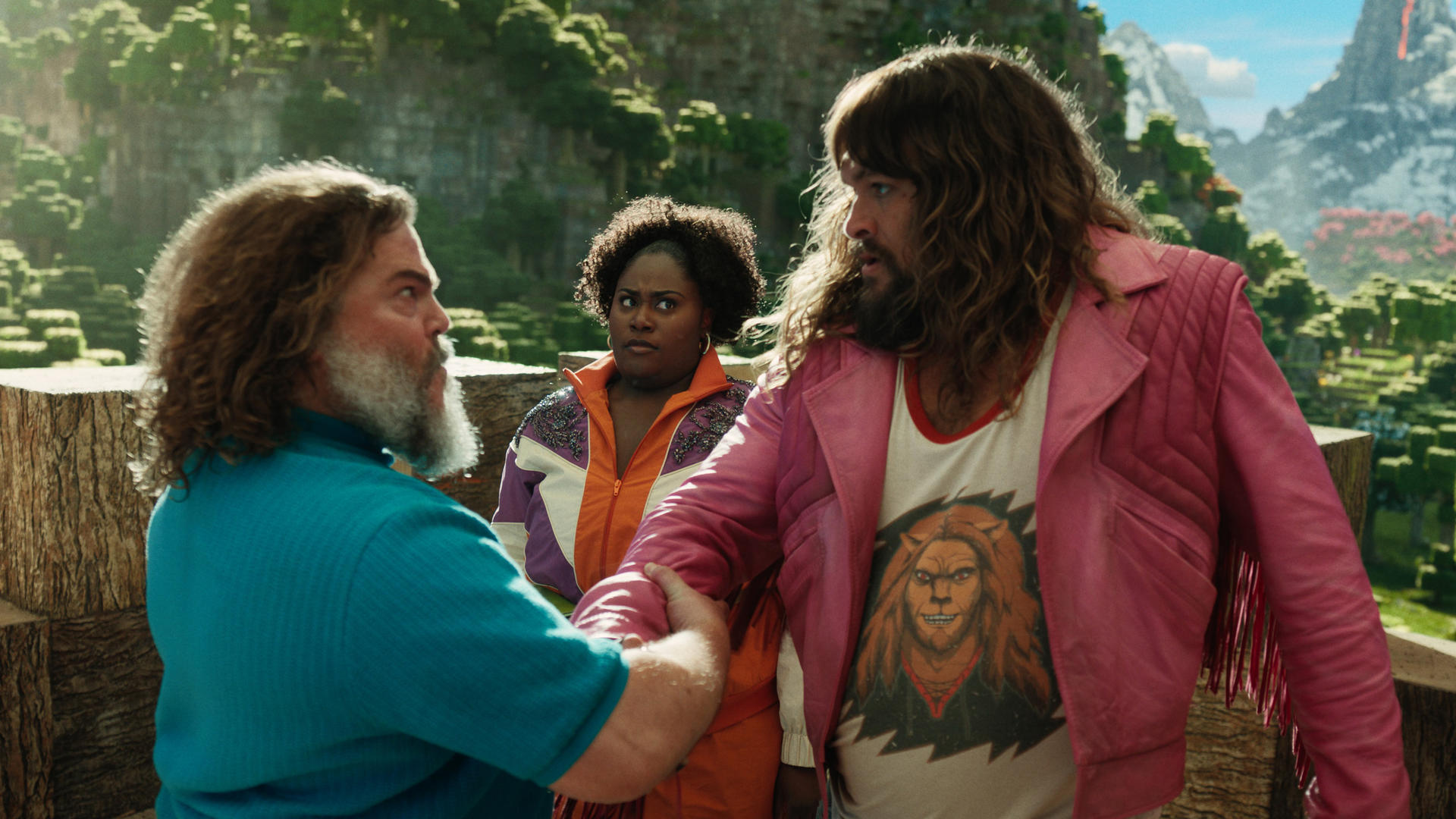 Drei Personen stehen zusammen. Einer trägt eine rosa Jacke, ein anderer eine orangefarbene Jacke.