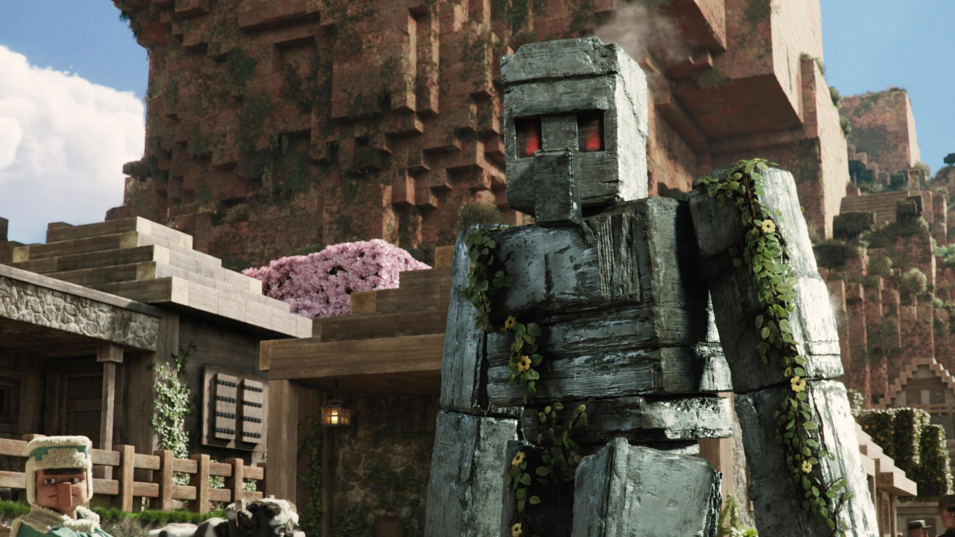 Ein Minecraft-Stil Stein-Golem steht vor Gebäuden mit bergigem Hintergrund.