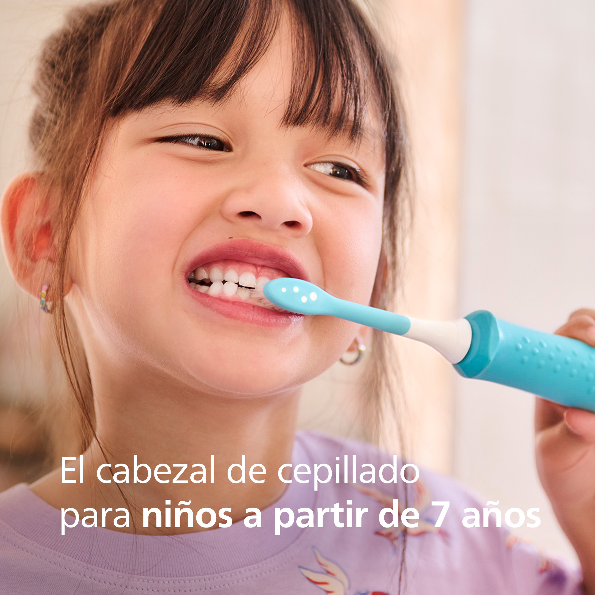 Una niña se cepilla los dientes con un cepillo de dientes azul, el texto dice "cabezal de cepillo para niños a partir de 7 años".