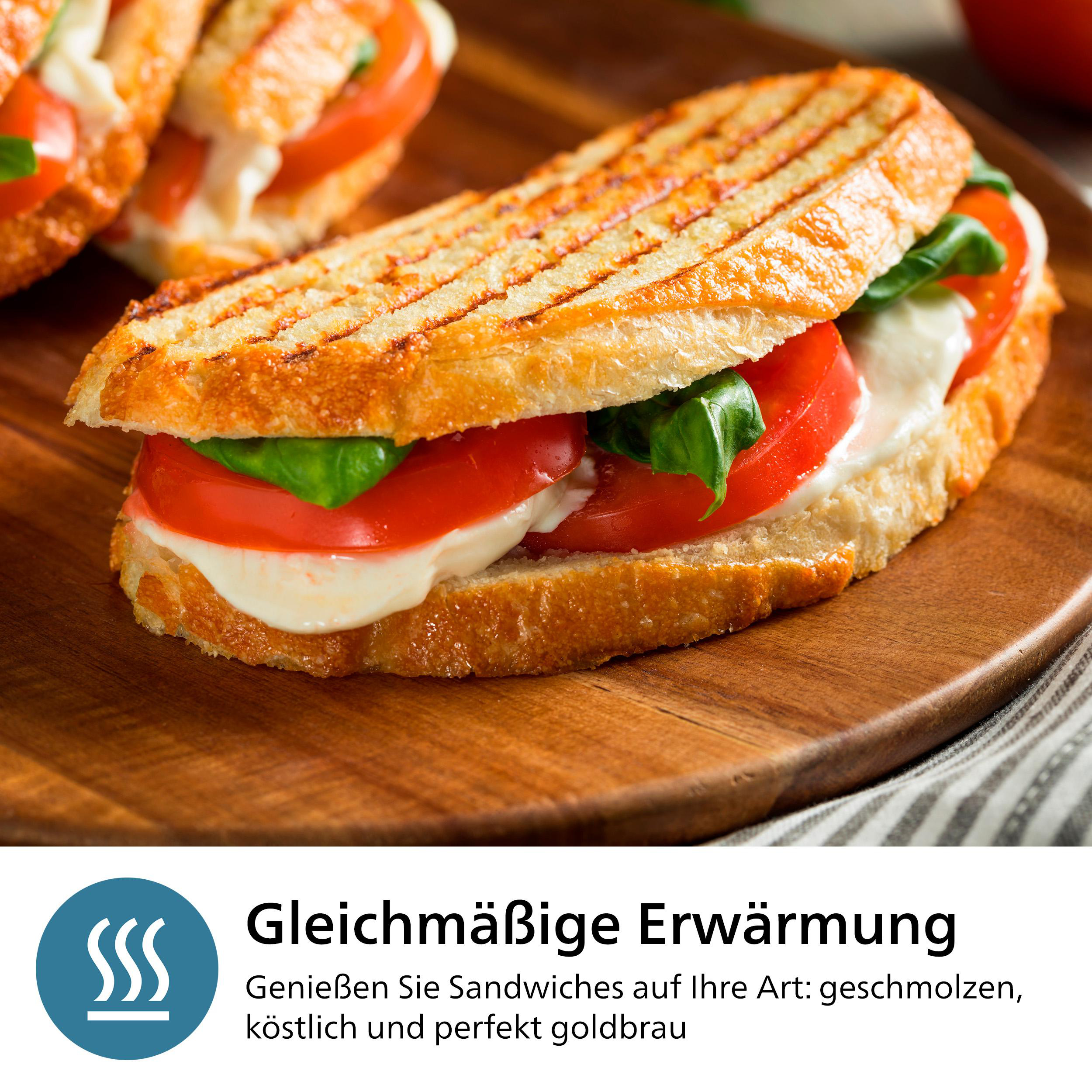 Ein gegrilltes Sandwich mit Tomaten, Mozzarella und Basilikum auf einem Holzbrett. Es ist angeschnitten.