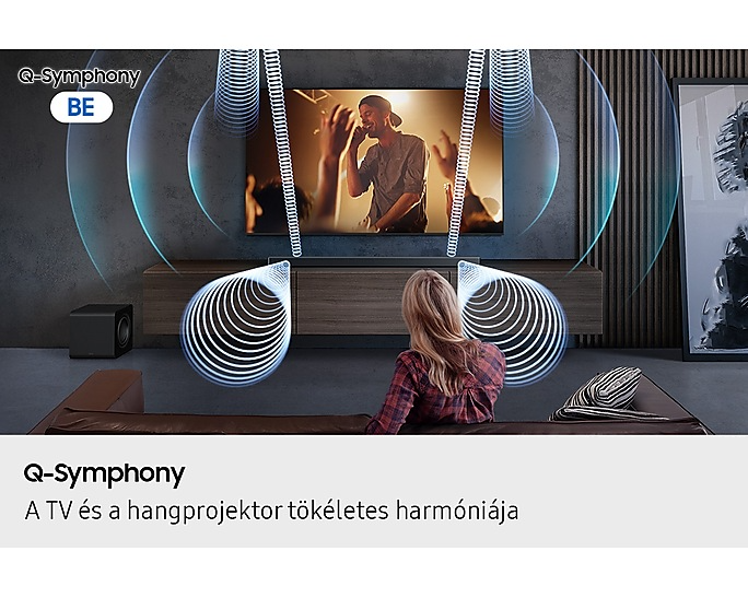 Nő a TV előtt soundbarral és mélynyomóval. Hanghullámok láthatók. A Q-Symphony kiemelve.