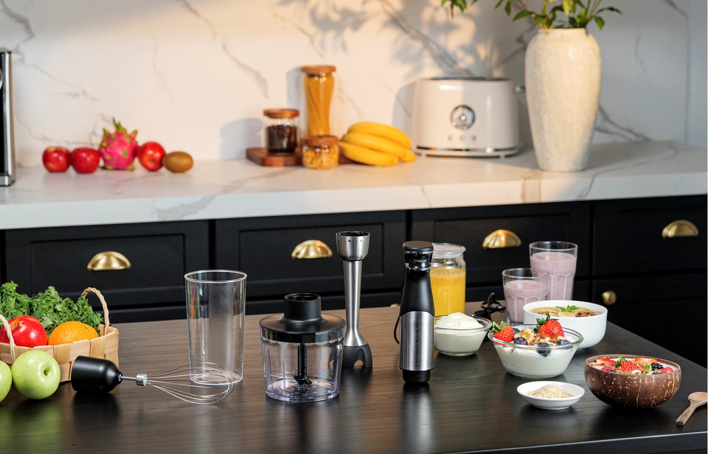 Küchenszene mit Mixer und verschiedenen Früchten und Gemüse auf dem Tisch, mit weißer Marmor-Rückwand.