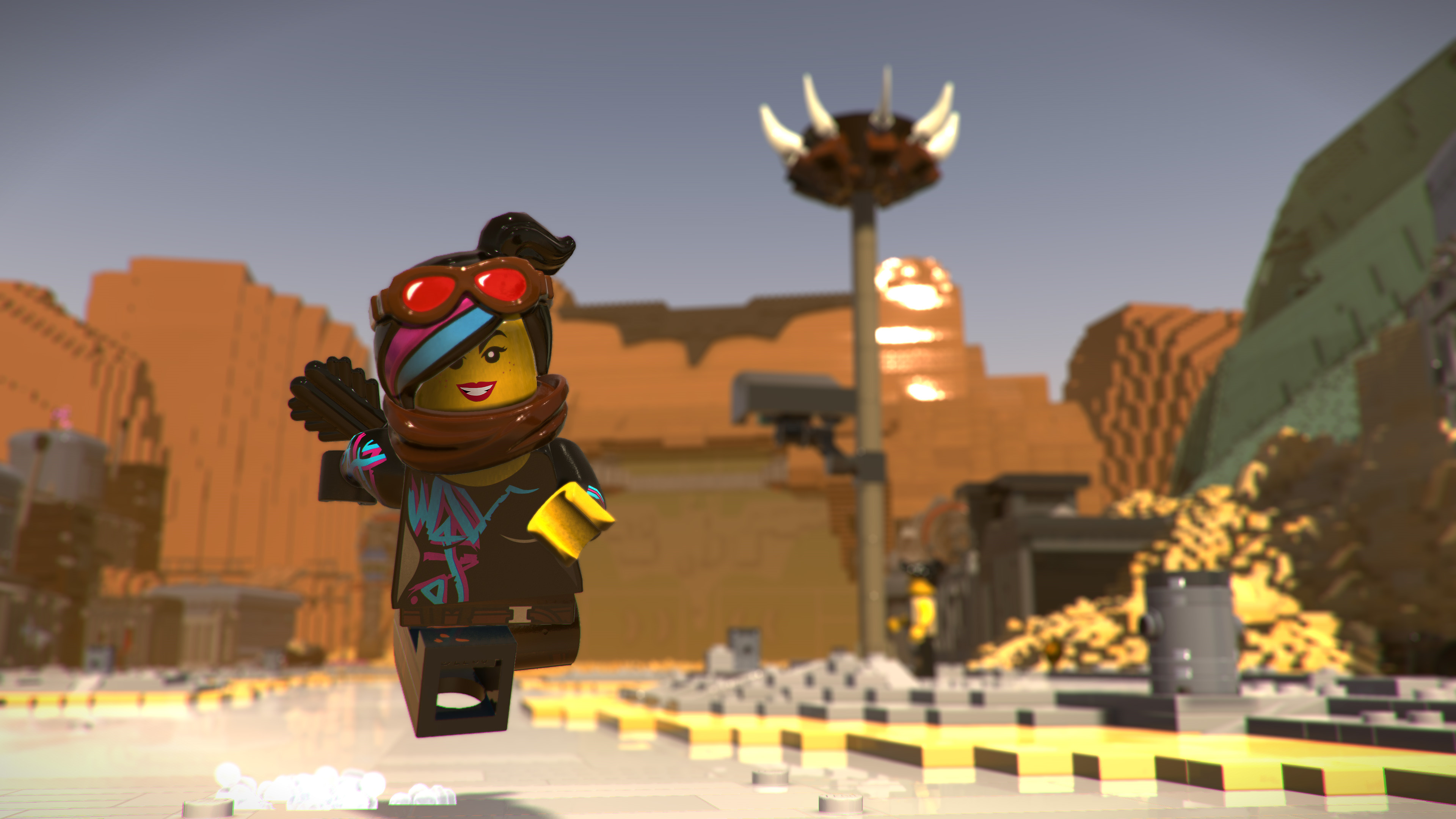 Personaggio Lego in un paesaggio desertico con una struttura alta e altre figure Lego.