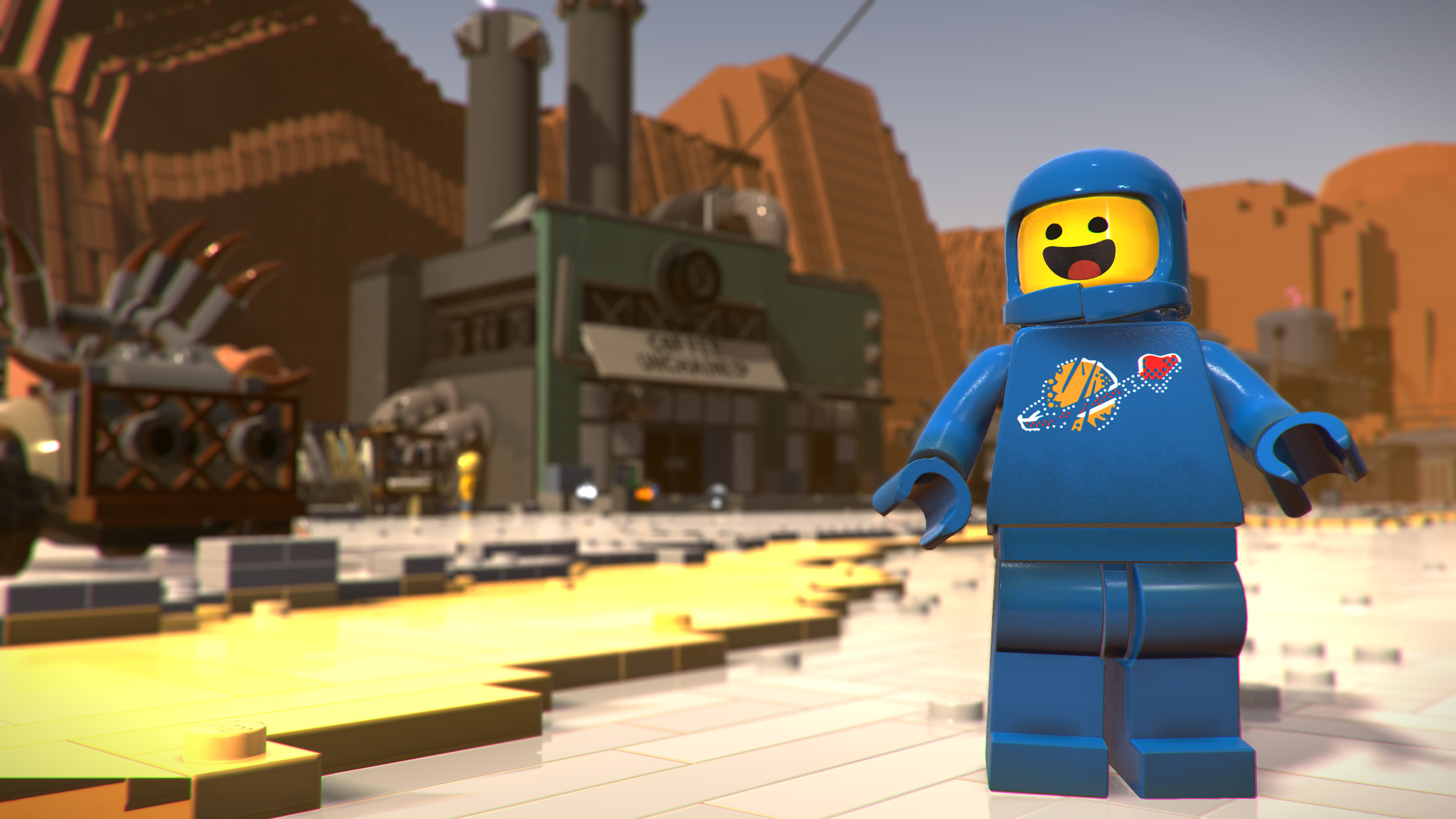 Astronauta Lego in una scena desertica, con una fabbrica e una struttura Lego sullo sfondo.