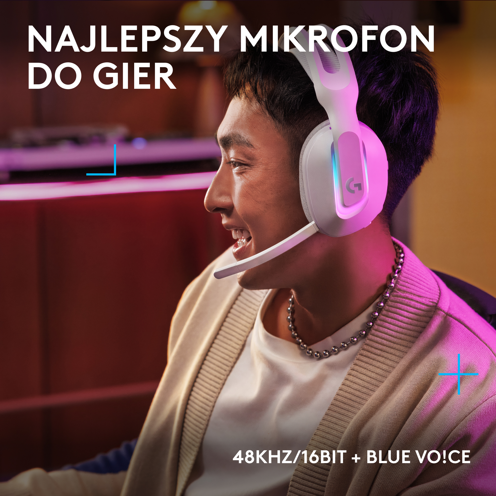 Mężczyzna w białym zestawie słuchawkowym uśmiecha się; mikrofon przy ustach.