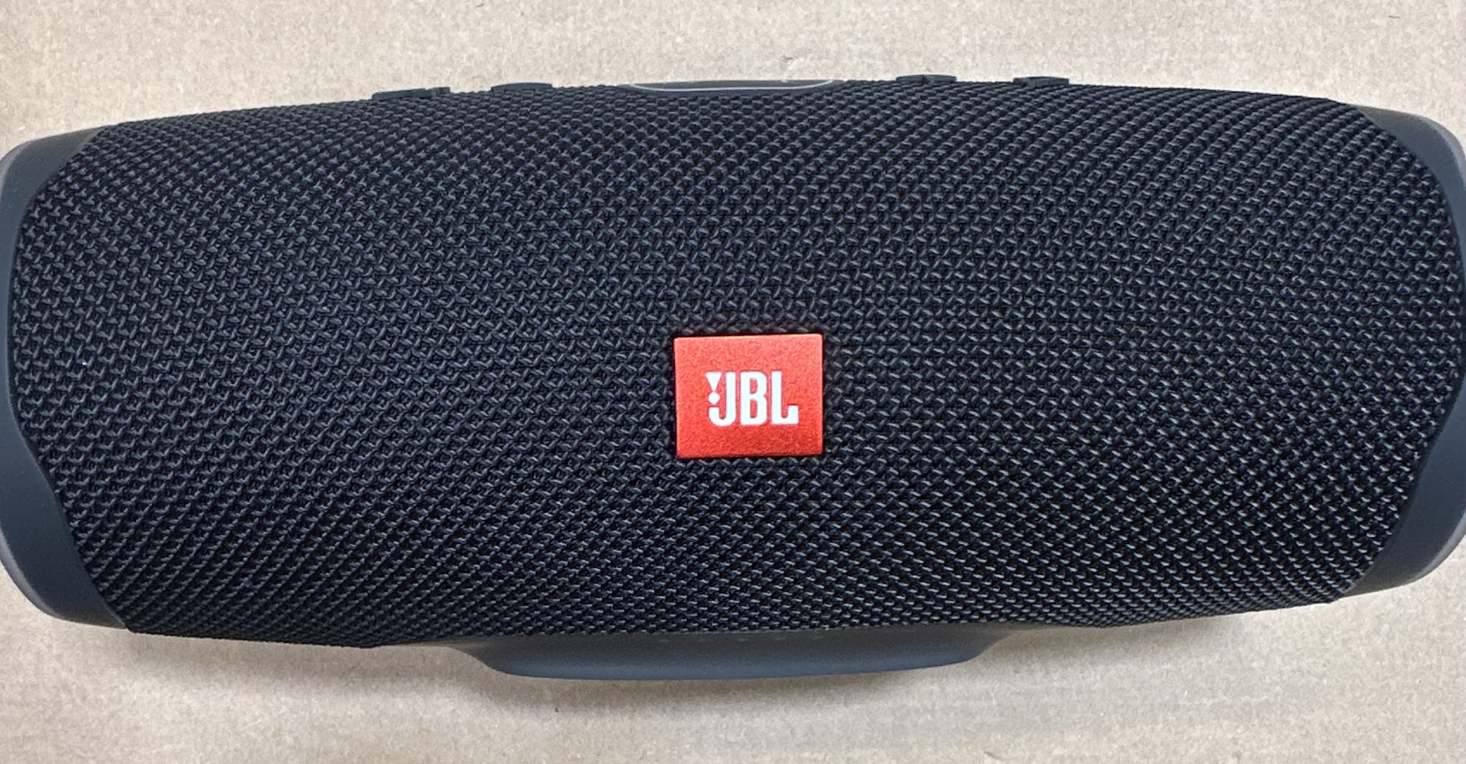 Czarny głośnik JBL Charge 5. Logo JBL jest czerwone z przodu.
