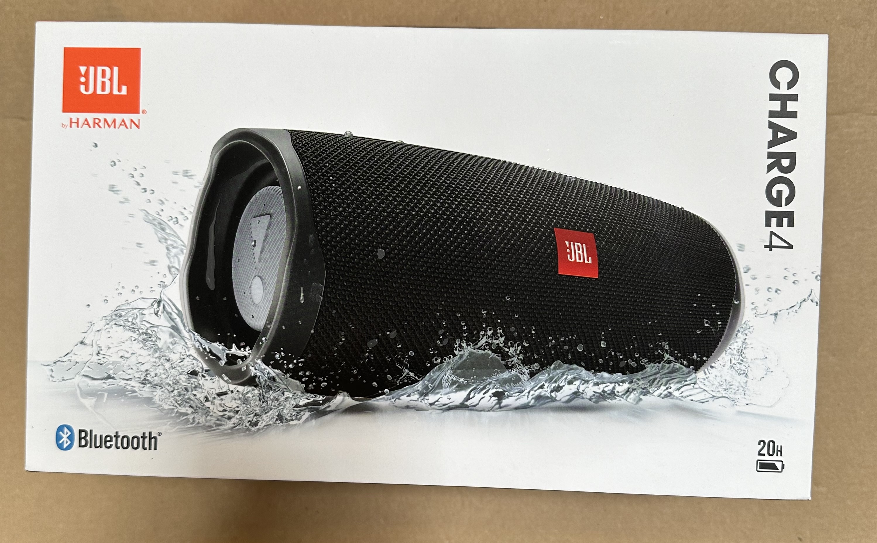 Głośnik JBL Charge 4 w pudełku z grafiką rozprysków wody, logo Bluetooth.