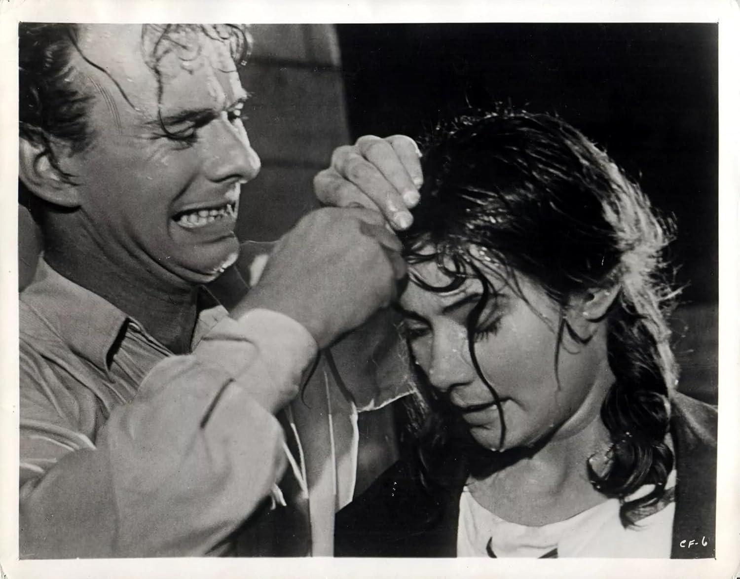 Mann hilft Frau, Wasser auf ihren Gesichtern, in Schwarzweiß-Filmstill.