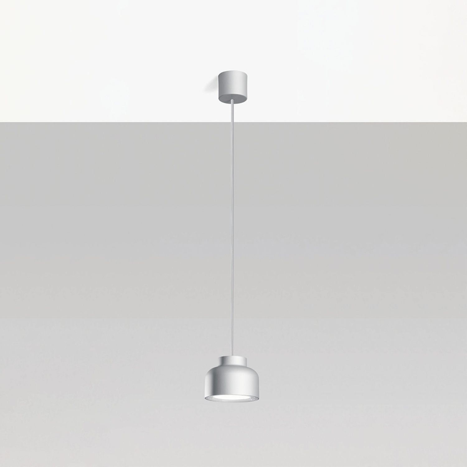 Una lampada a sospensione appesa al soffitto. La lampada è argento e bianca.