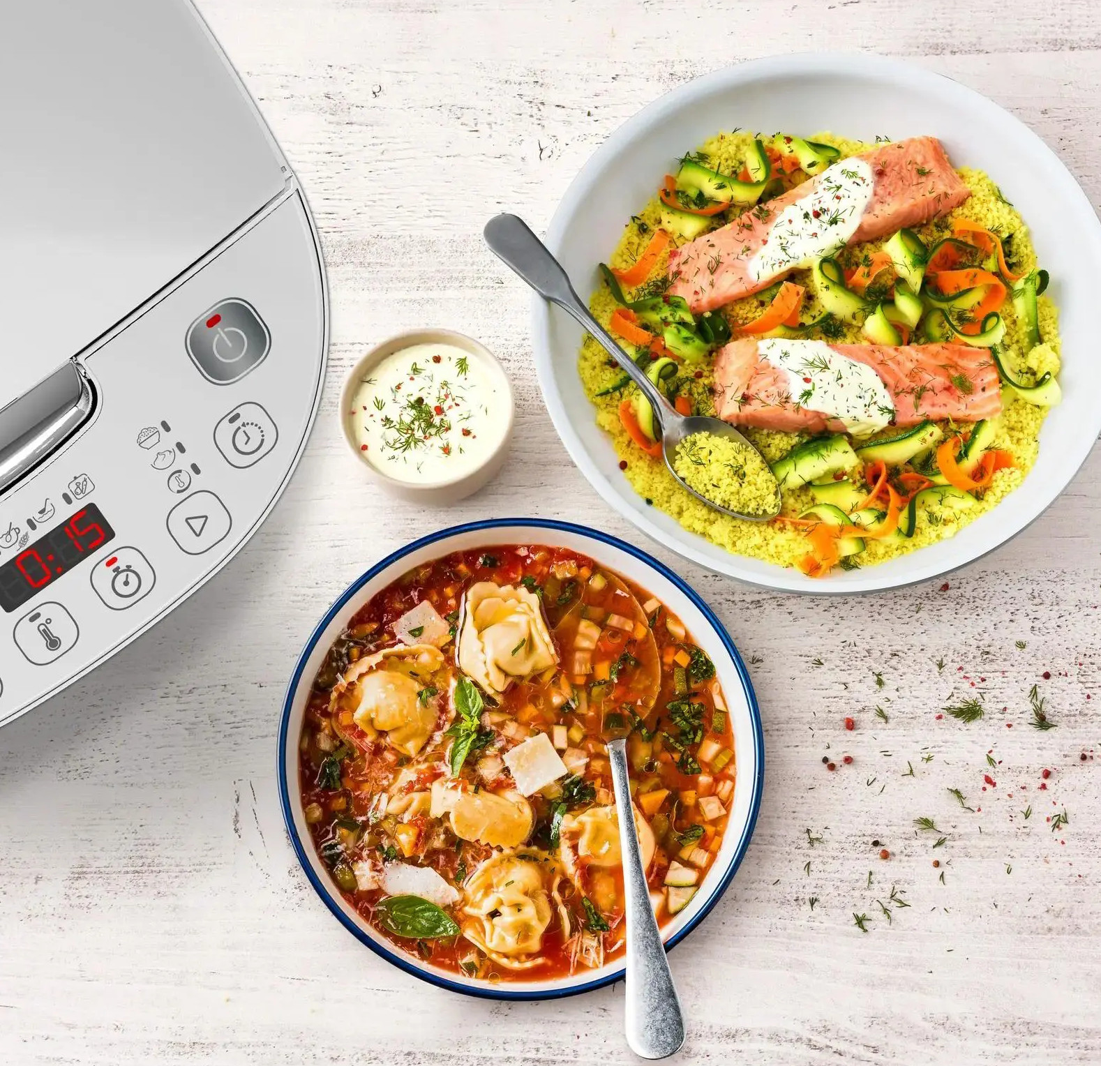 Maszynka do ryżu i kus-kus z łososiem z zupą na białym stole.