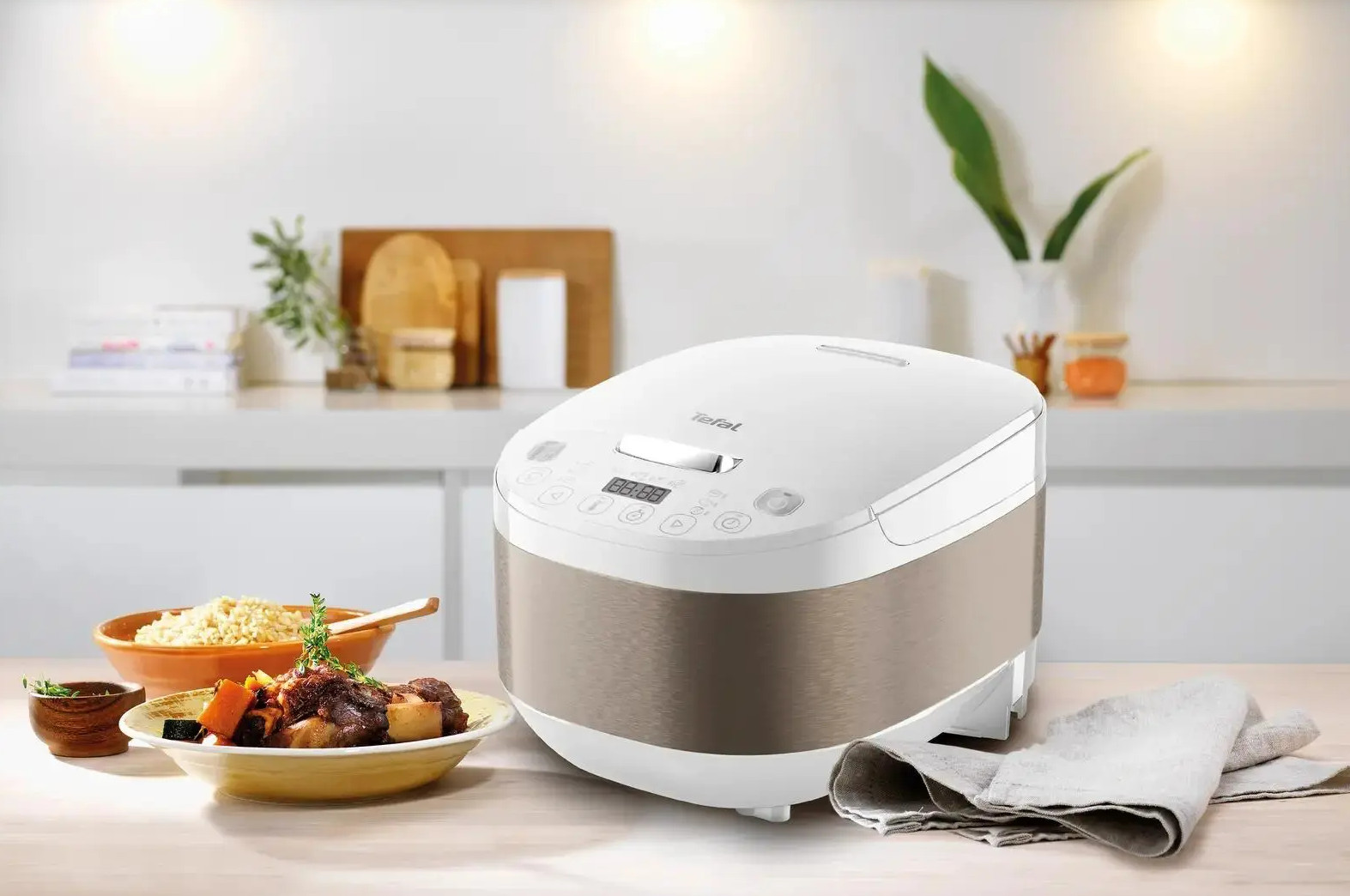 Biała maszynka do ryżu na stole z naczyniami na stole.