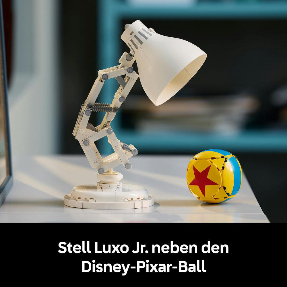 Luxo Jr. Lampe und Pixar-Ball auf weißer Oberfläche. Die Lampe ist weiß, der Pixar-Ball daneben.