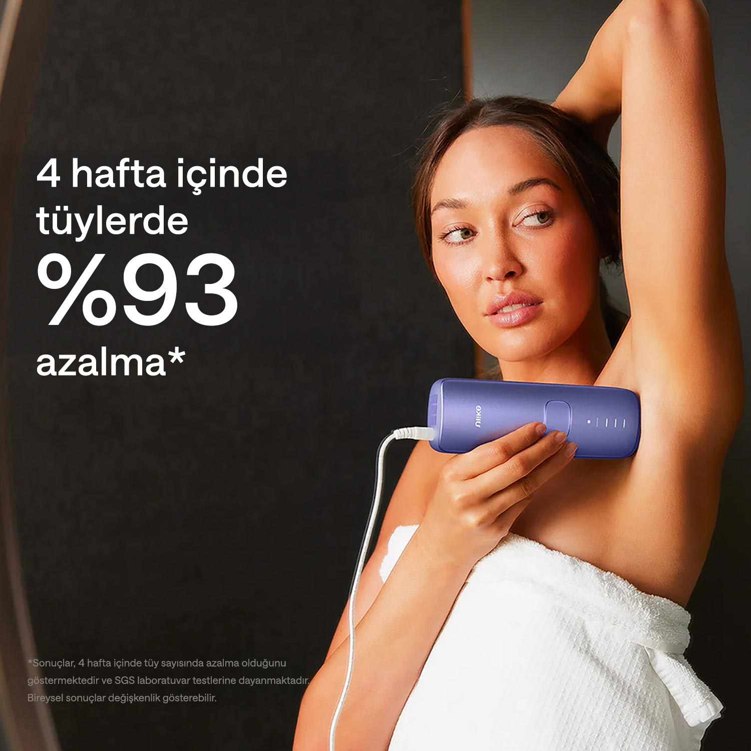 Kadın cihazı koltuk altında kullanıyor. Cihaz prize takılı ve kabloya bağlı.