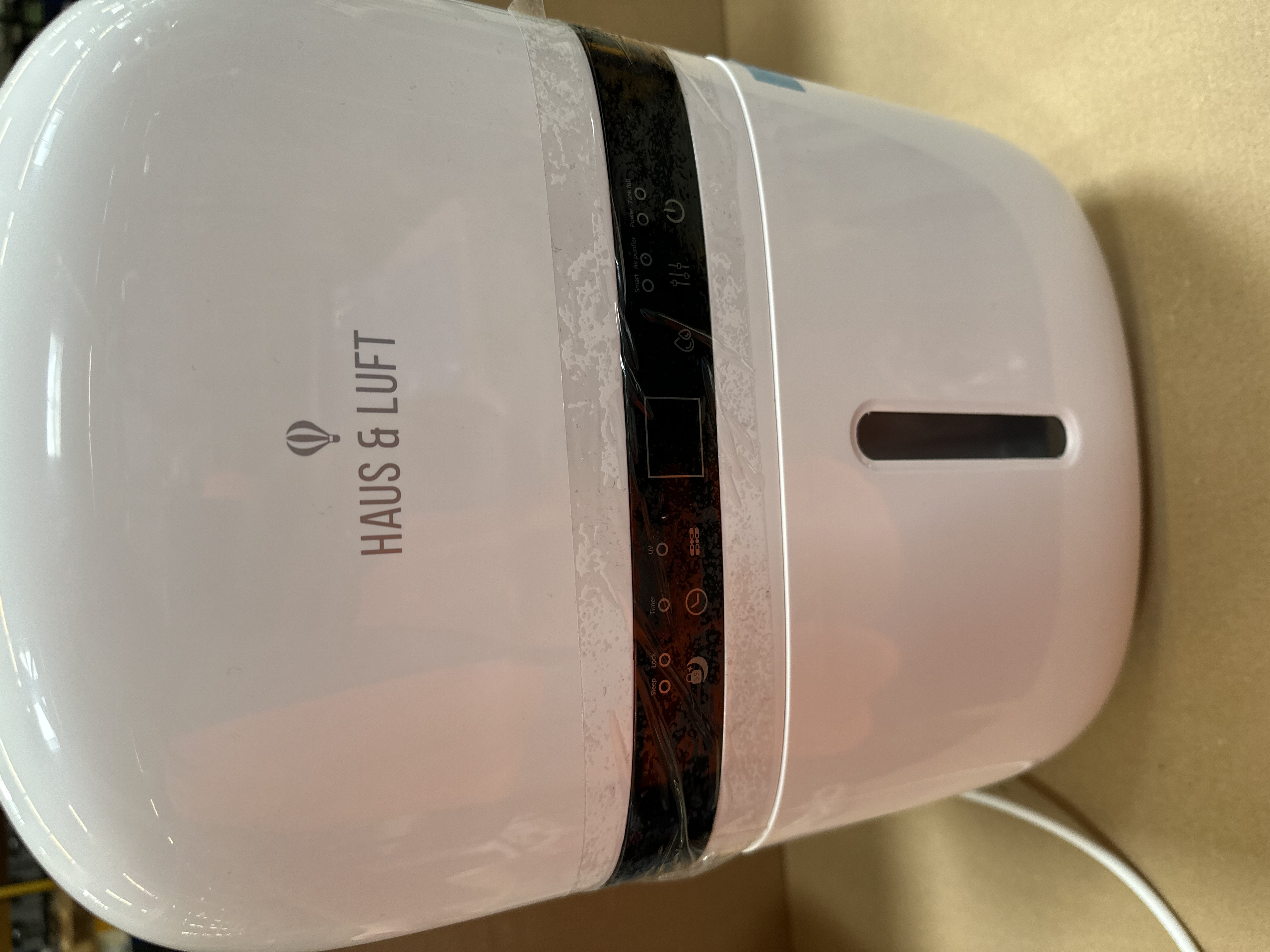 Biały nawilżacz z nadrukowanym logo i wyświetlaczem.