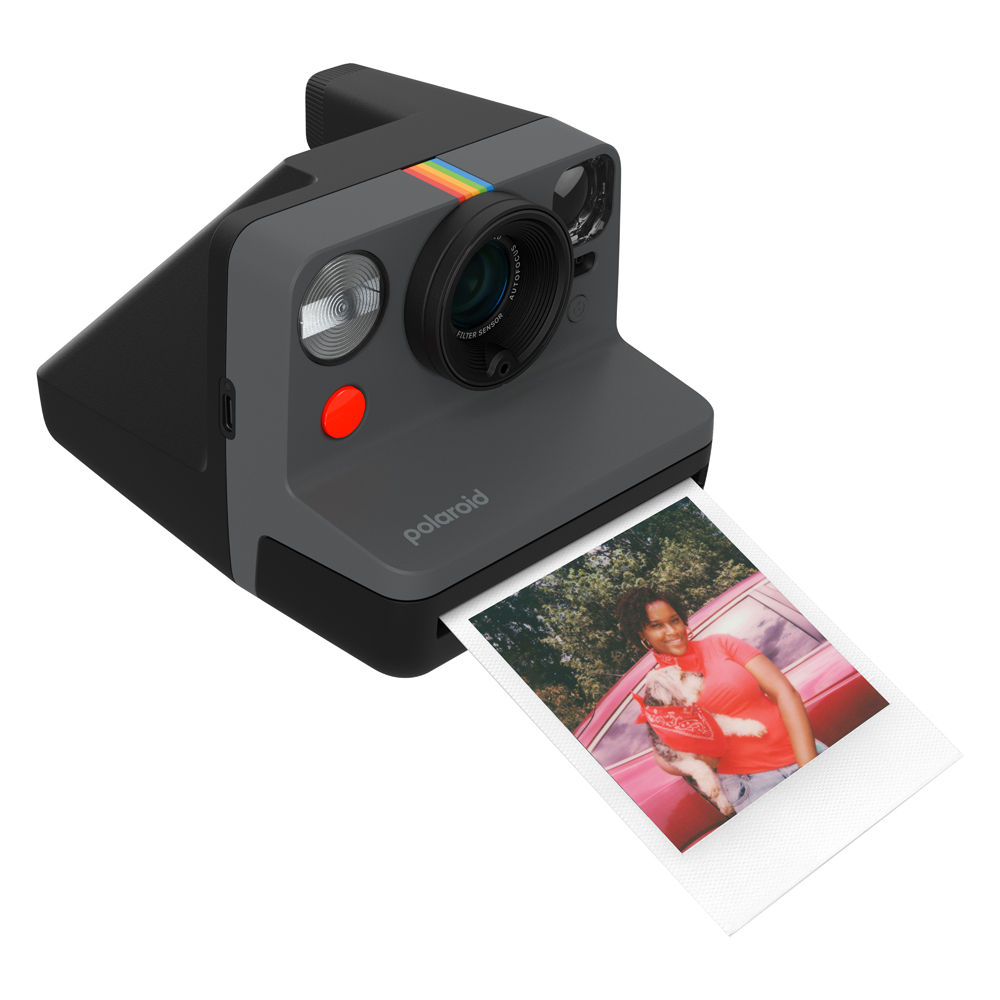 Bir kişi ve köpeğin fotoğrafının olduğu bir Polaroid kamera. Kameranın üstünde gökkuşağı şeridi var.