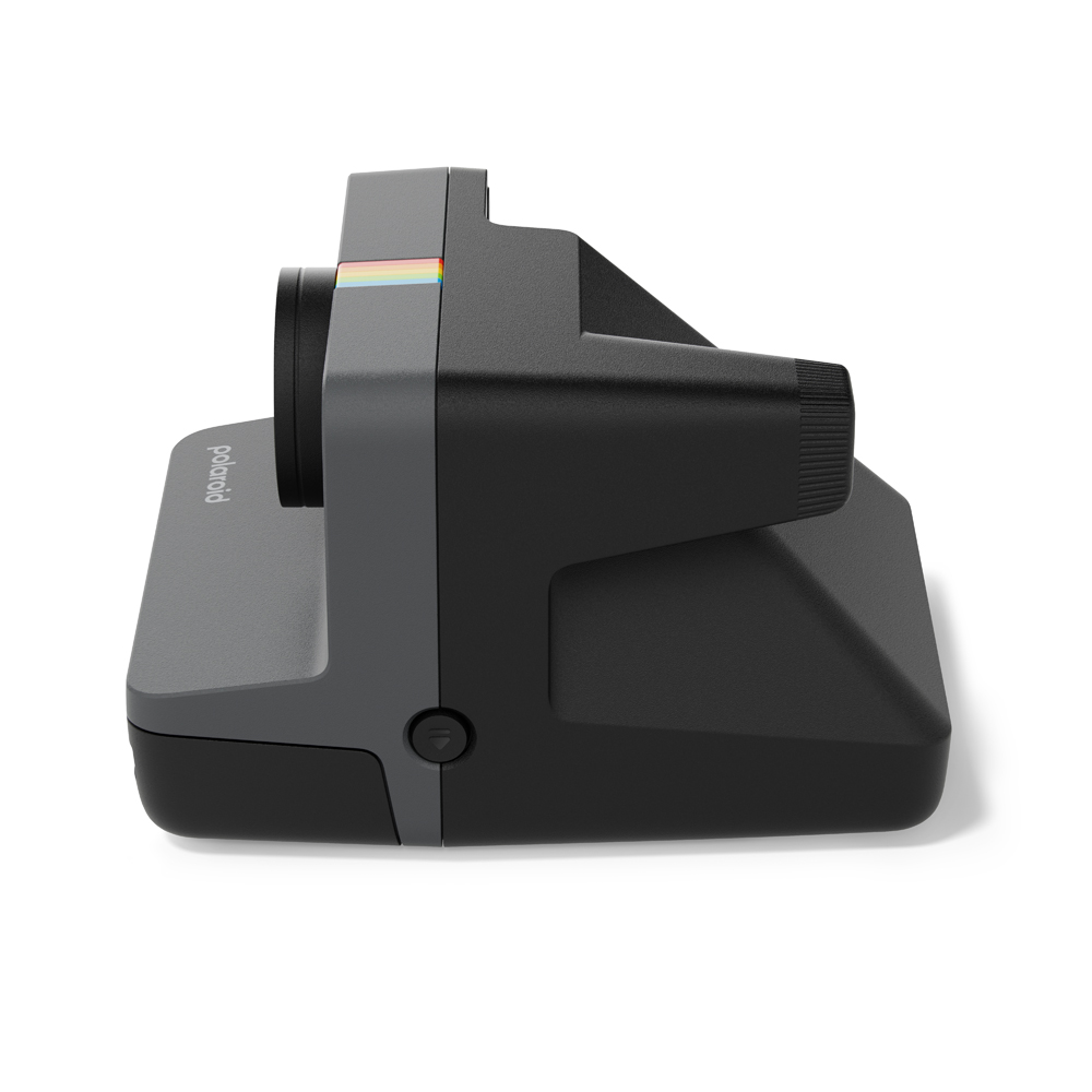 Polaroid kamera, siyah ve gri, yan görünüm, beyaz zemin üzerinde.