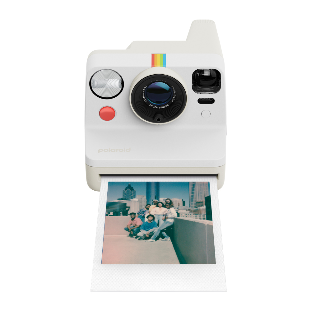 Bir grup insanın dışarı atıldığı bir fotoğrafı olan beyaz bir Polaroid kamera.