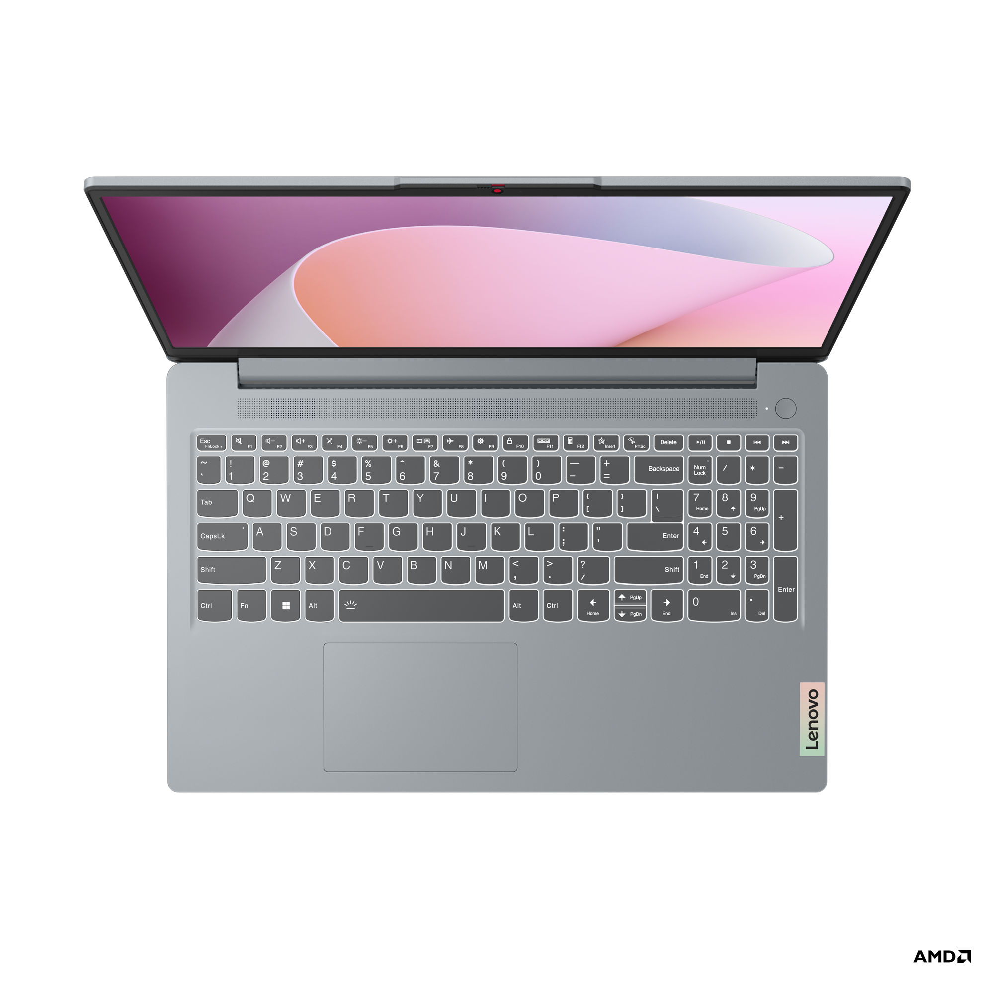 Masada açık bir dizüstü bilgisayar. Pembe ve gri ekran, beyaz klavye ve Lenovo logosu.