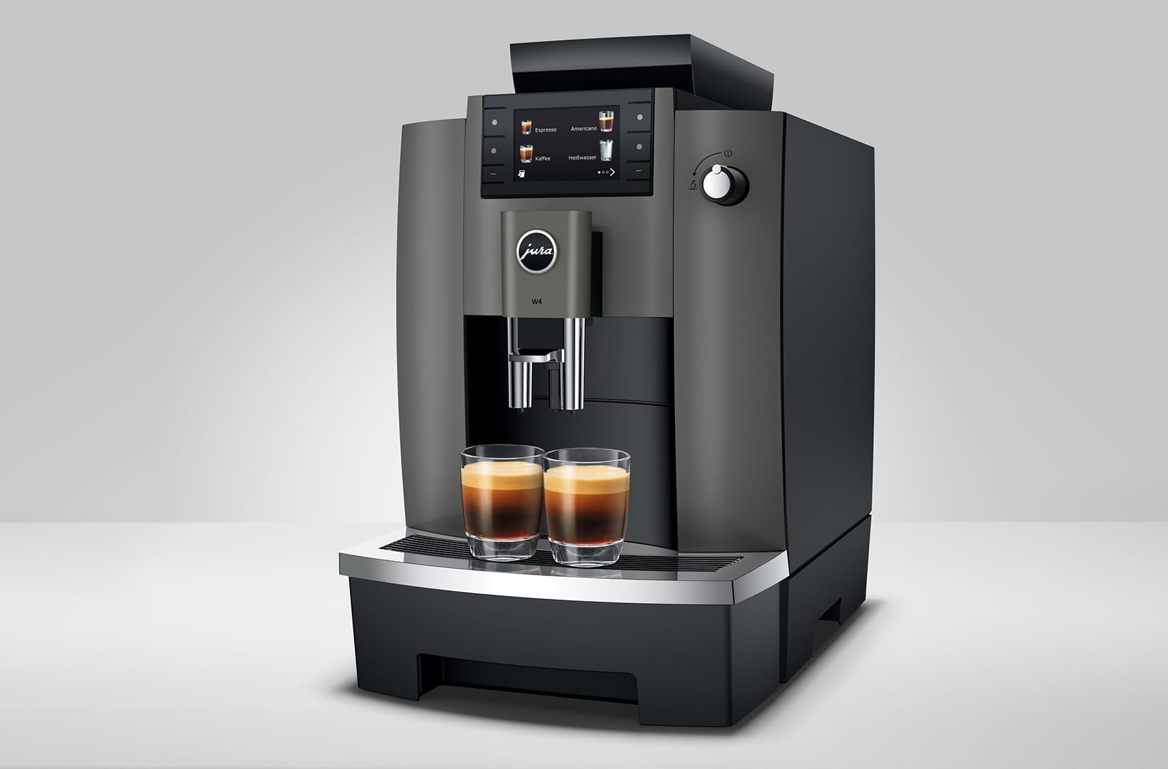 Macchina da caffè con due bicchieri di caffè. Il display mostra le selezioni di bevande.