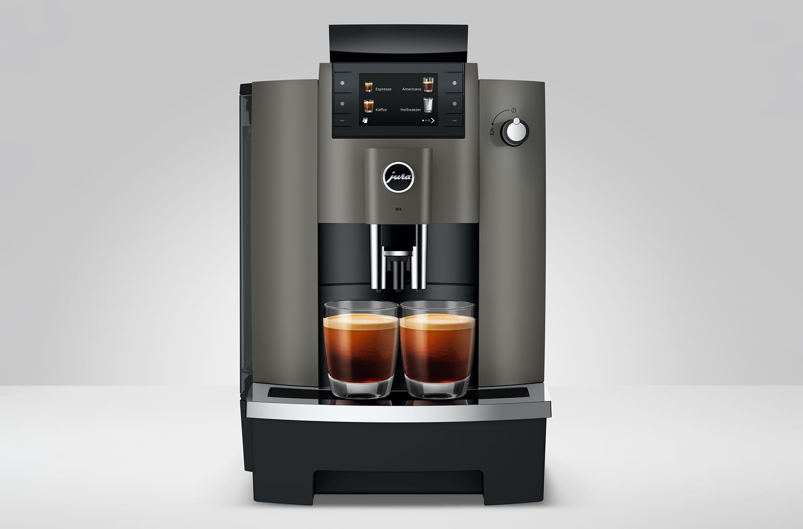 Macchina da caffè con due bicchieri di caffè, display che mostra le opzioni di bevande.