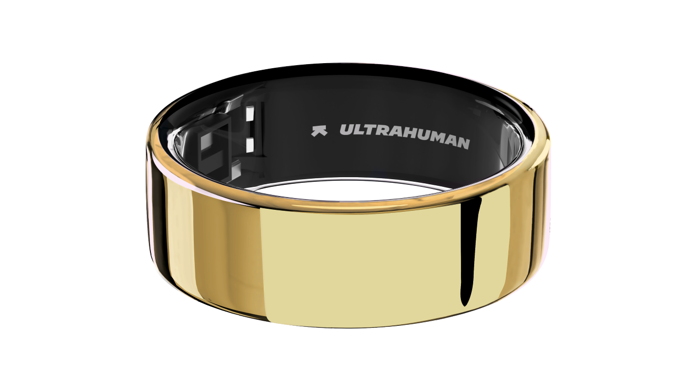Złoty smart ring z czarnym wnętrzem, widoczne logo 'ULTRAHUMAN'. Czarne tło.