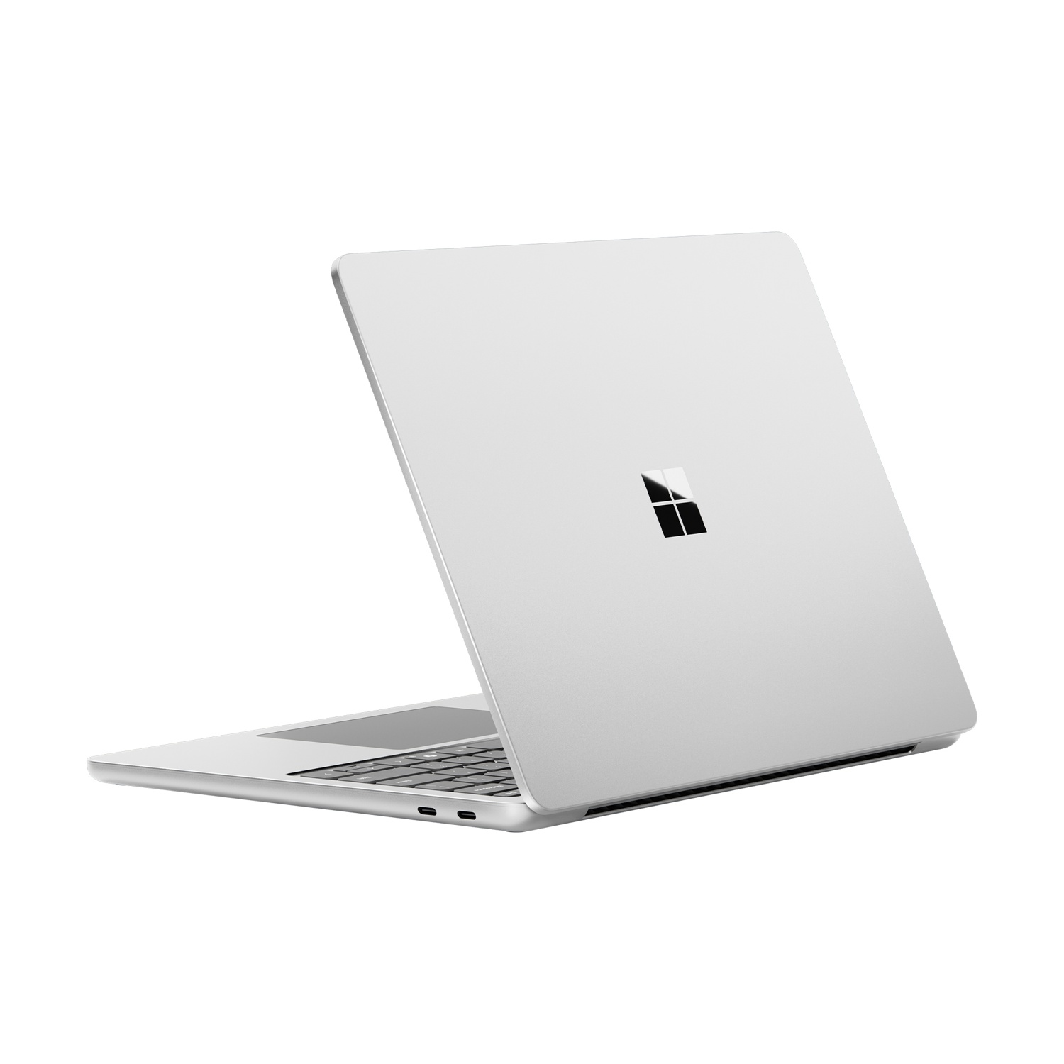 Laptop argentato, aperto, con il logo Microsoft sul retro, su sfondo bianco.