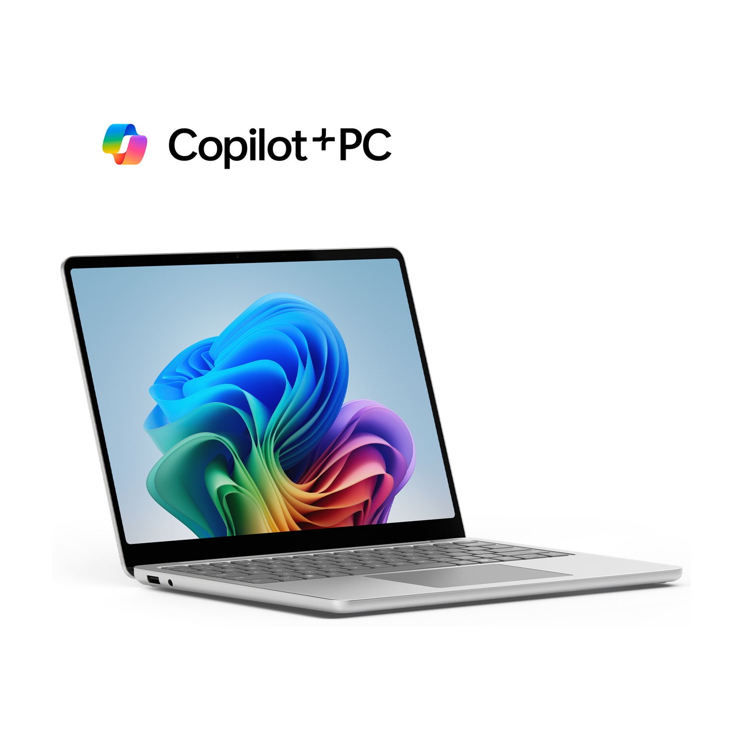 Laptop argentato con schermo colorato, logo Copilot+PC. Sfondo bianco.