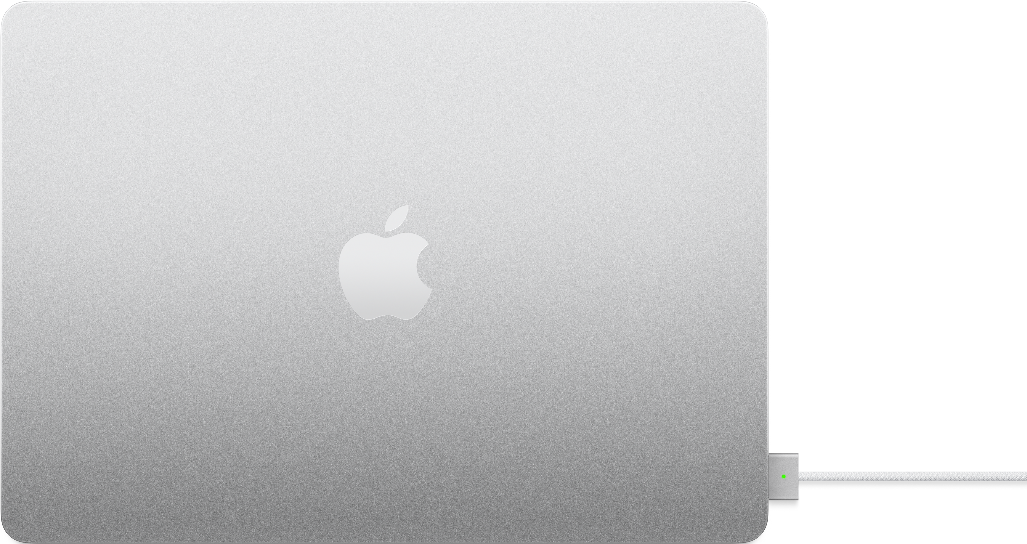 Ordinateur portable argenté avec le logo Apple sur le couvercle, câble de charge connecté.
