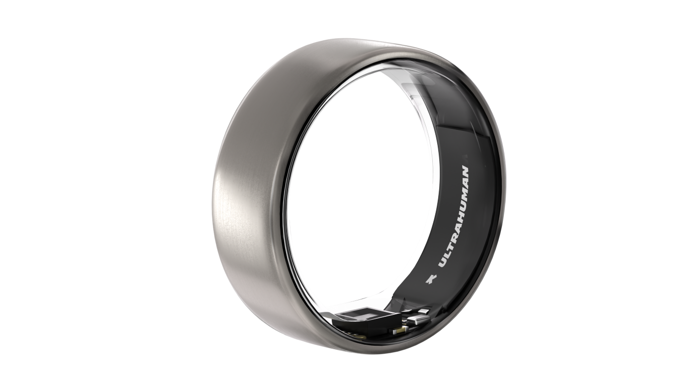 Srebrny smart ring na czarnym tle. Pierścień ma ciemne wnętrze z nazwą marki. Tło jest czarne.