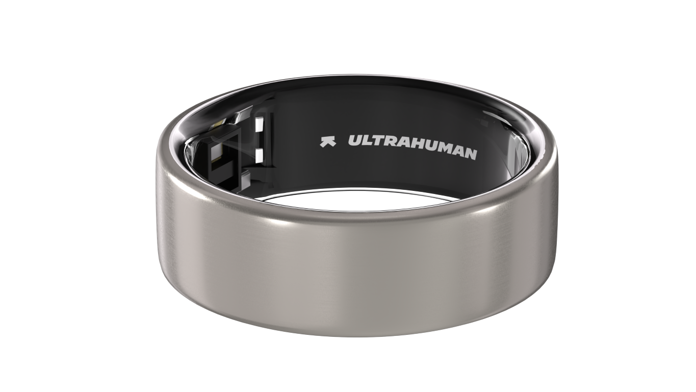 Srebrny smart ring z czarnym wnętrzem. Nazwa marki jest widoczna wewnątrz pierścienia. Czarne tło.