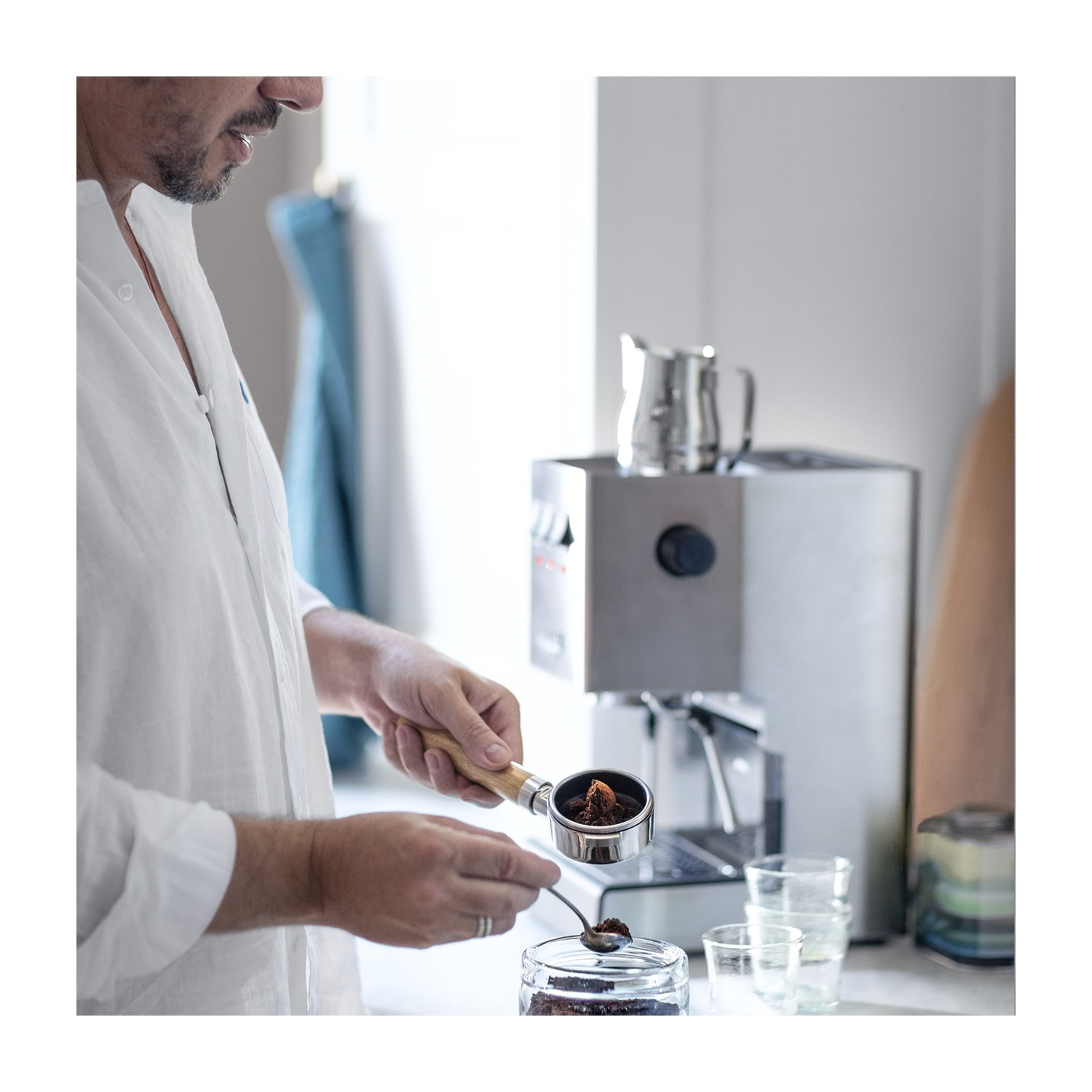 Persona che fa l'espresso. Riempiendo il portafiltro con caffè macinato.