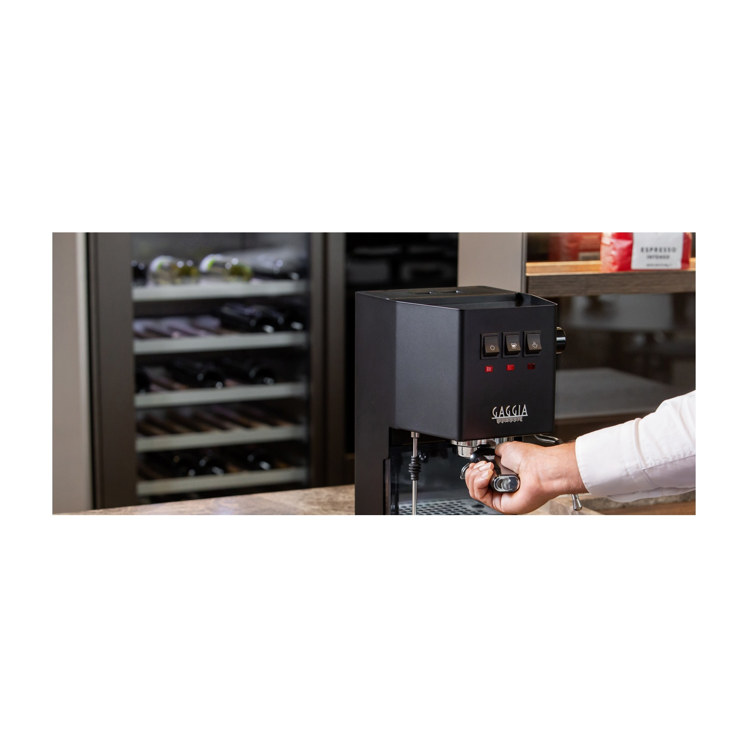 Una persona aziona una macchina per caffè espresso nera.