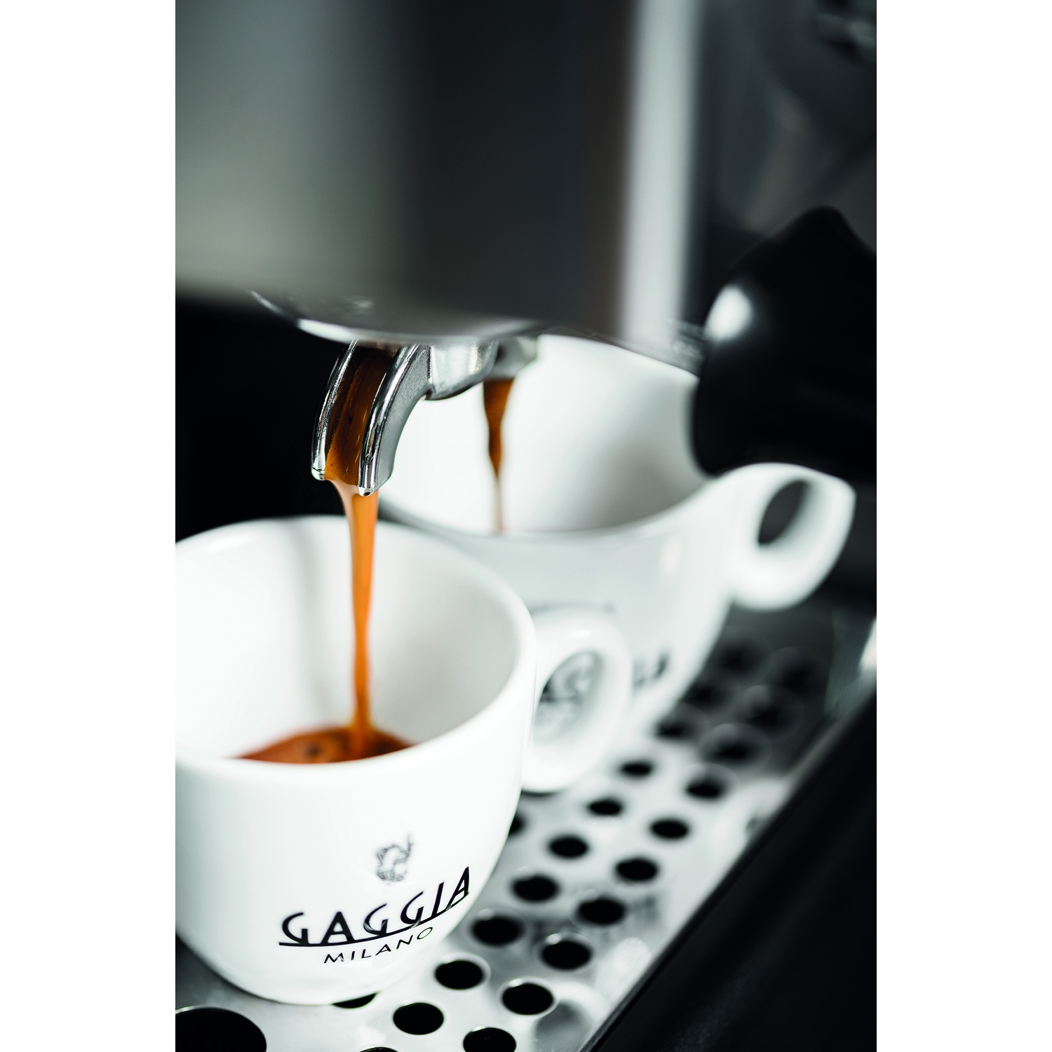 Espresso che esce da una macchina in due tazze bianche su un vassoio.