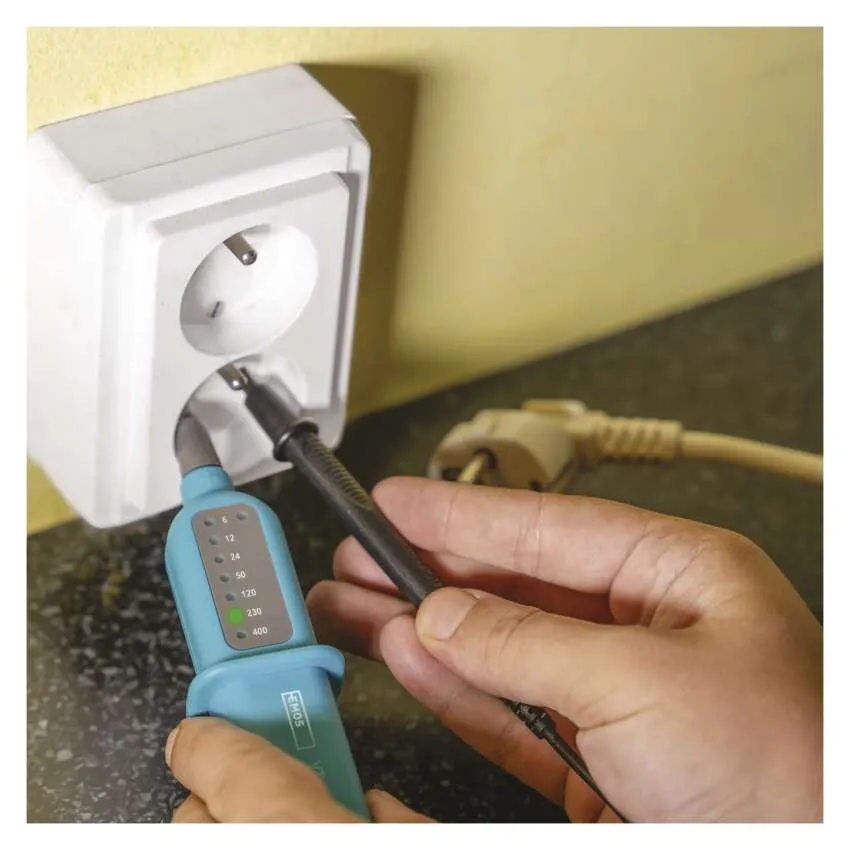 Személy feszültségvizsgálóval egy elektromos aljzaton.