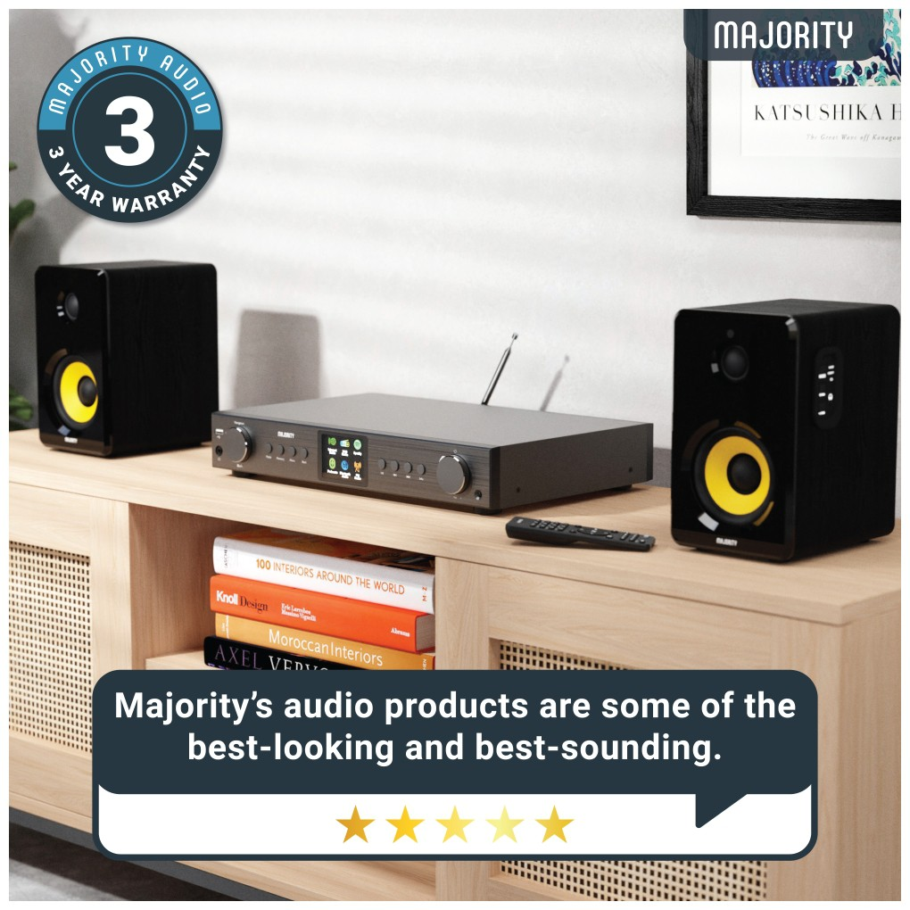 Configuration audio avec des enceintes, un récepteur et une télécommande sur un meuble en bois.