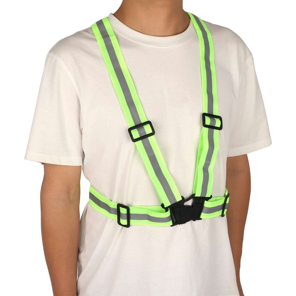 Persona con chaleco de seguridad neón con rayas reflectantes y broches negros.