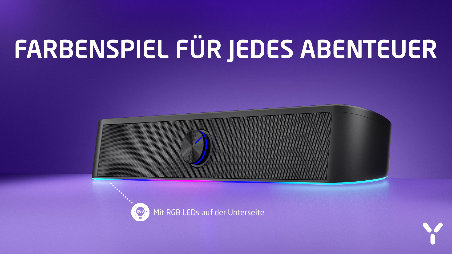Czarny głośnik z diodami LED RGB. Tekst: Farbenpiel für jedes Abenteuer. Głośnik stoi na fioletowej powierzchni.