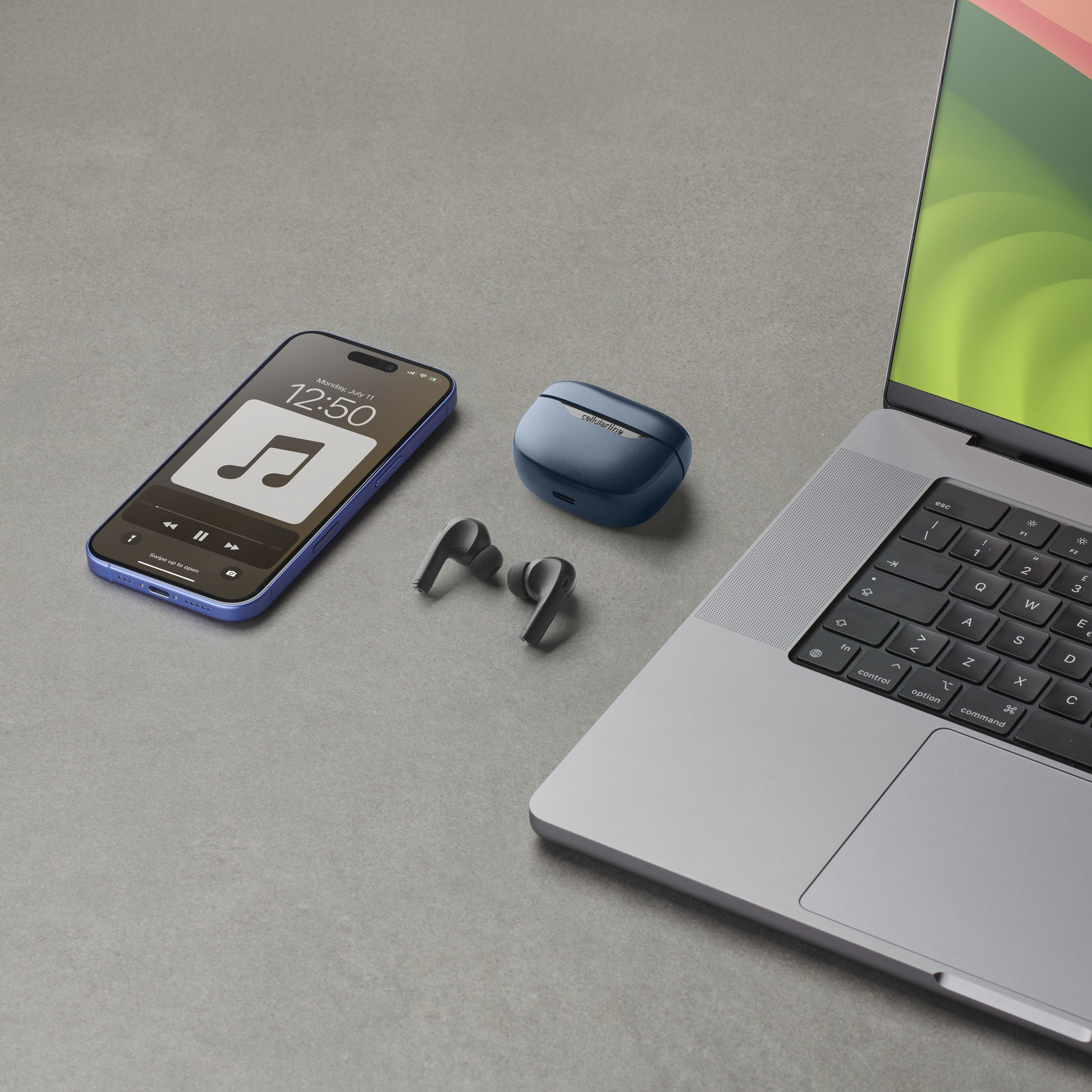 Gri bir yüzeyde kulaklıklar, kutu, telefon ve dizüstü bilgisayar. Telefon müzik uygulamasını gösteriyor.