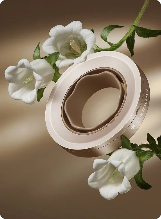 Dyfuzor do suszarki do włosów, ze złotą podstawą i białymi kwiatami wokół.