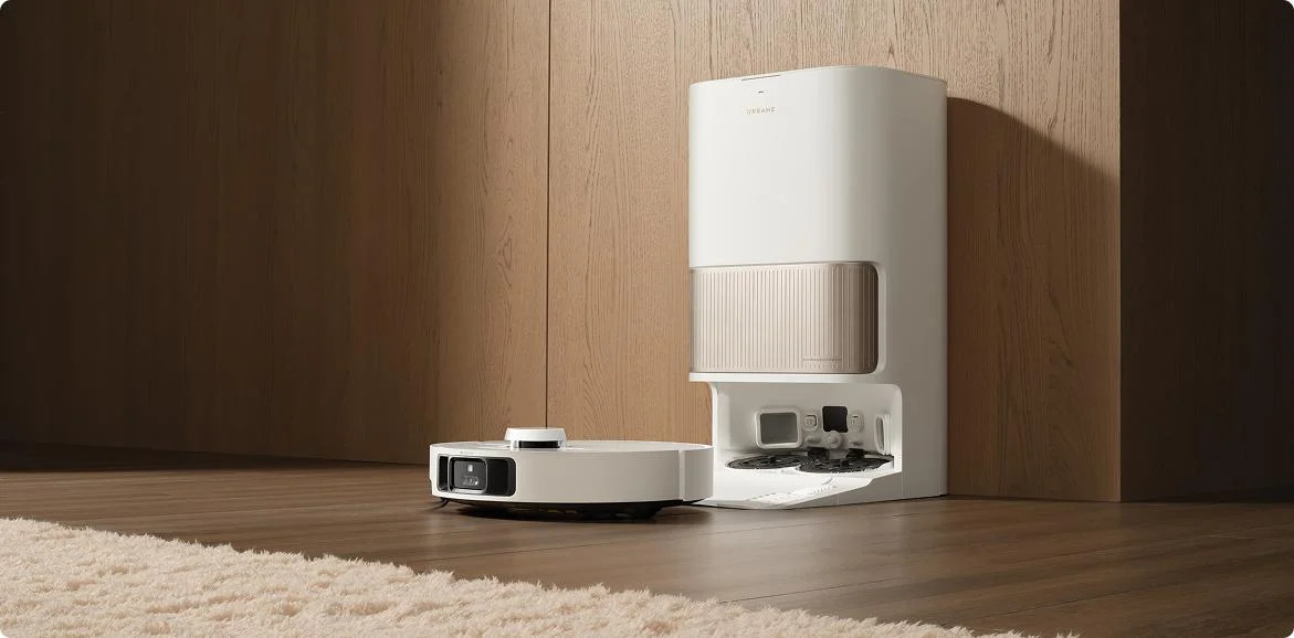 Robot odkurzający ze stacją ładującą. Stacja i odkurzacz są białe.