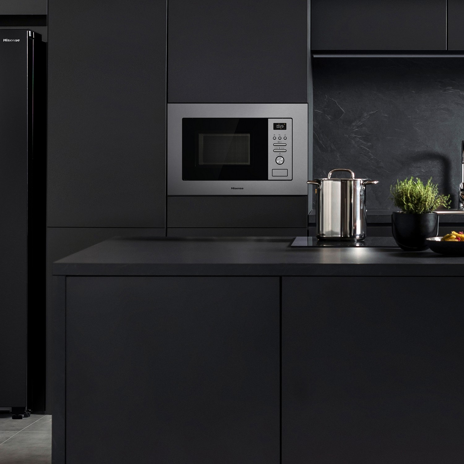 Cocina negra moderna con microondas. El microondas está integrado en los armarios sobre la encimera.