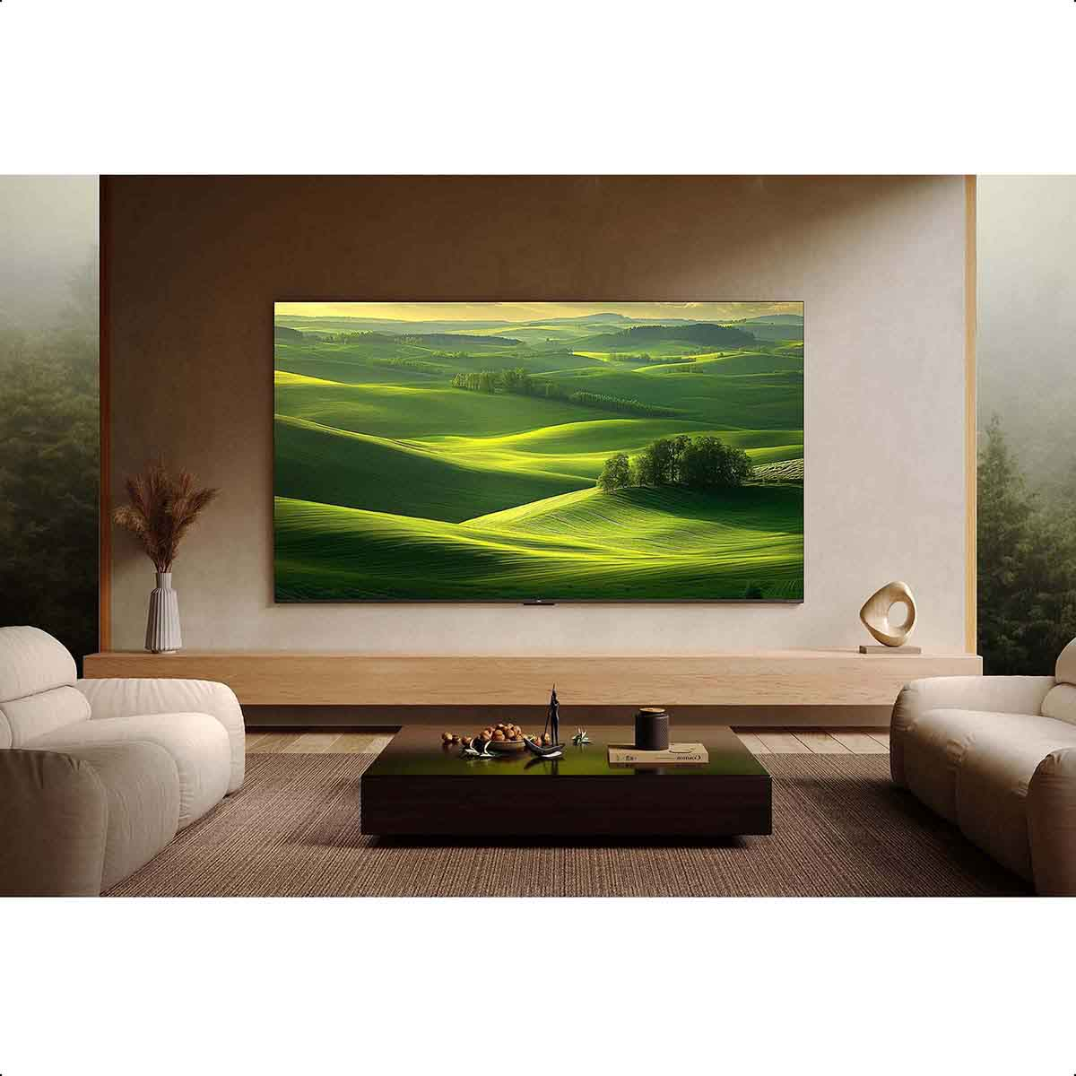 Wohnzimmer mit großem Fernseher, der eine grüne Landschaft zeigt. Zwei Sofas und ein Couchtisch.